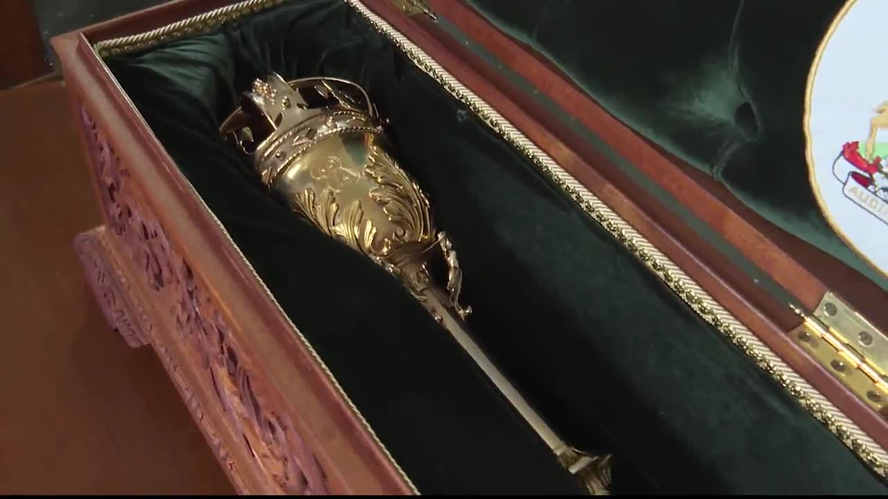 Inside a wooden case, the Ontario Legislative Assembly Mace gleams, resting against a deep green velvet lining. The ornate gold-plated staff, with its crown-like top, is ready for the next session.
