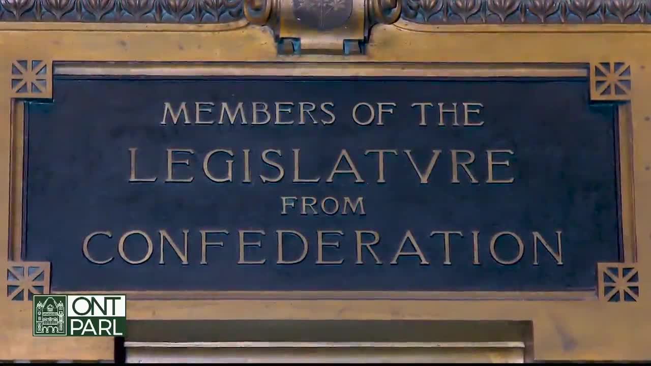 The sign, framed in gold, reads "Members of the Legislature from Confederation." Below, the Ontario Legislative Assembly logo is visible.
