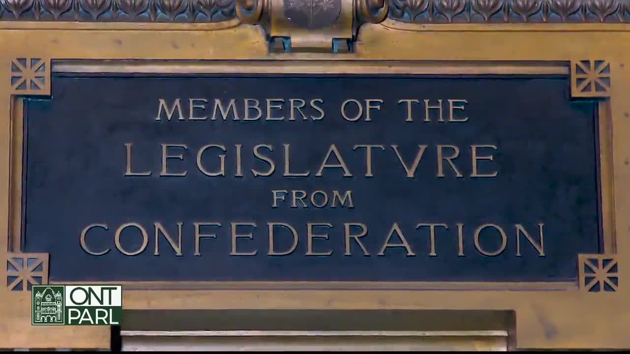 The words "Members of the Legislature from Confederation" are etched in gold against a dark, rectangular plaque. Below, the logo for Ontario Parliament is visible.
