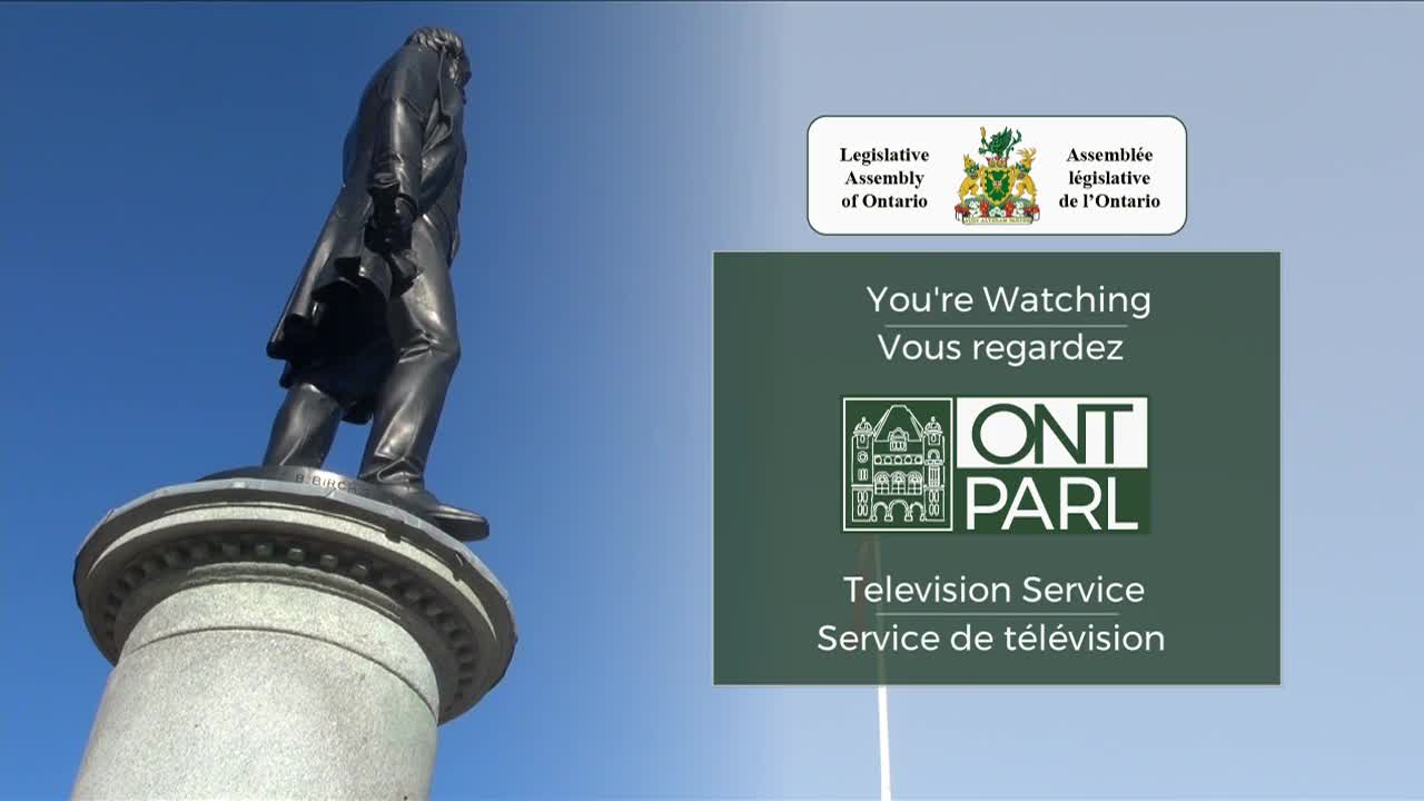 A statue of a man stands tall against a bright blue sky, while the Legislative Assembly of Ontario's television service logo is displayed. The broadcast is announcing that you're watching.
