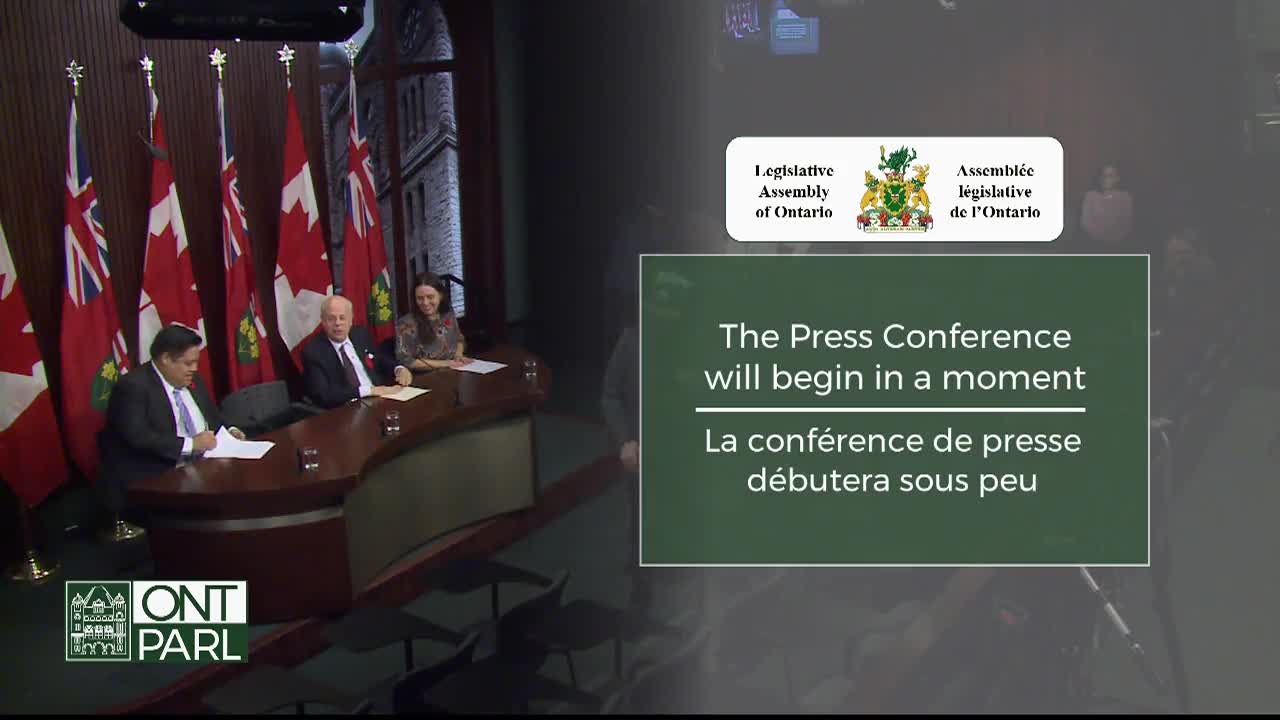 Three people sit behind a curved desk, papers in front of them, with Canadian flags and the Ontario Legislative Assembly logo visible. A message on the screen confirms the press conference will start soon.
Three people sit behind a curved desk, papers in front of them, with Canadian flags and the Ontario Legislative Assembly logo visible. A message on the screen confirms the press conference will start soon.