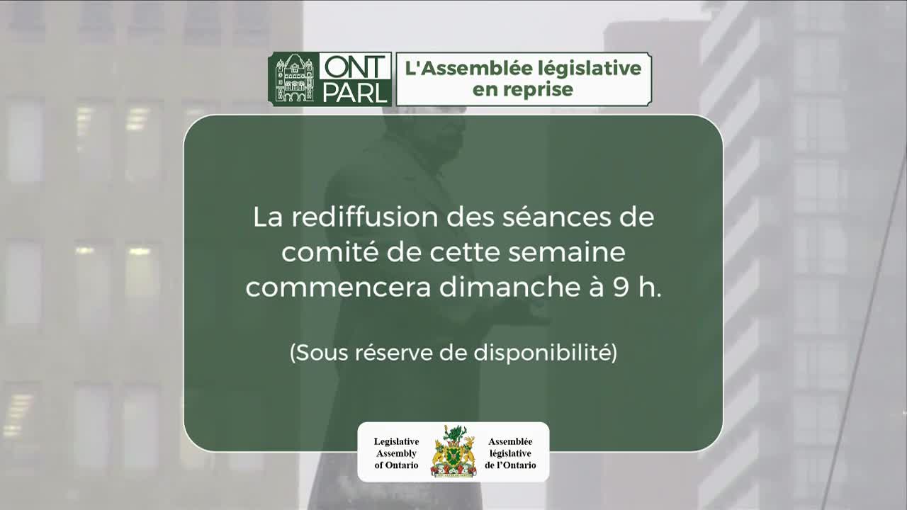 A man in a suit stands before a building with many windows. Text overlays the scene, announcing that this week's committee sessions will be re-broadcast starting Sunday at 9 AM.