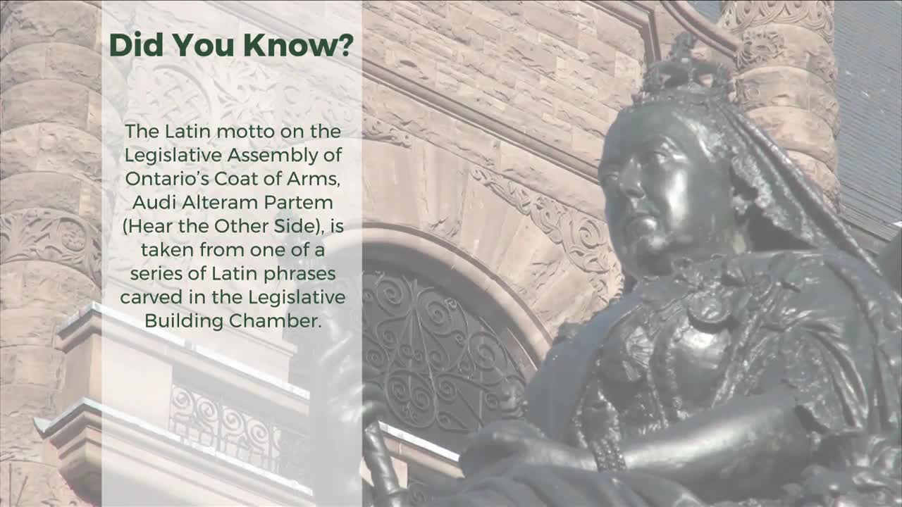 A bronze statue of Queen Victoria sits before the stone facade of the Legislative Building in Ontario. The Queen's stern gaze looks out from beneath her crown, her detailed robes catching the light.