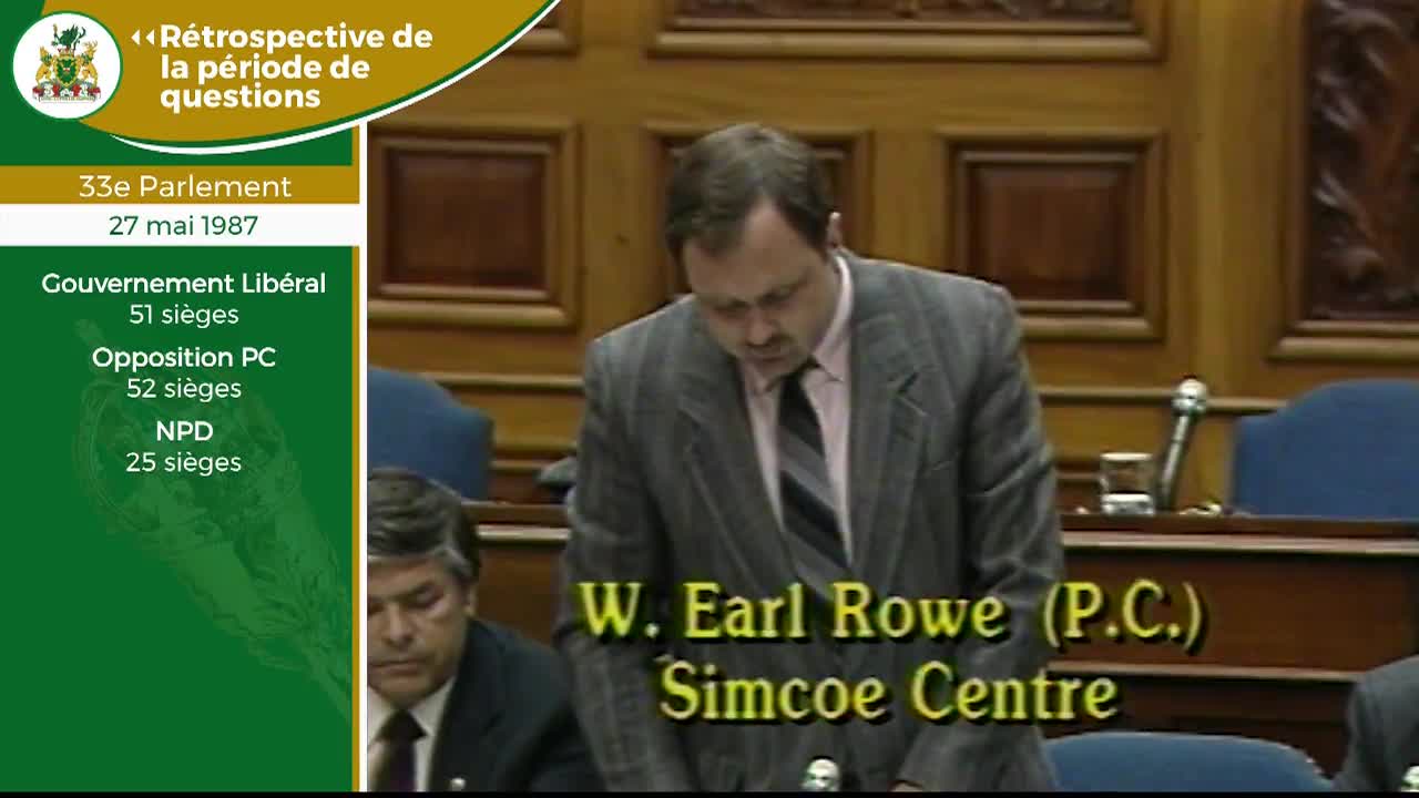 A man in a pinstripe suit stands at a podium, his head bowed. The Legislative Assembly of Ontario is in session, as indicated by the French text overlaying the scene.