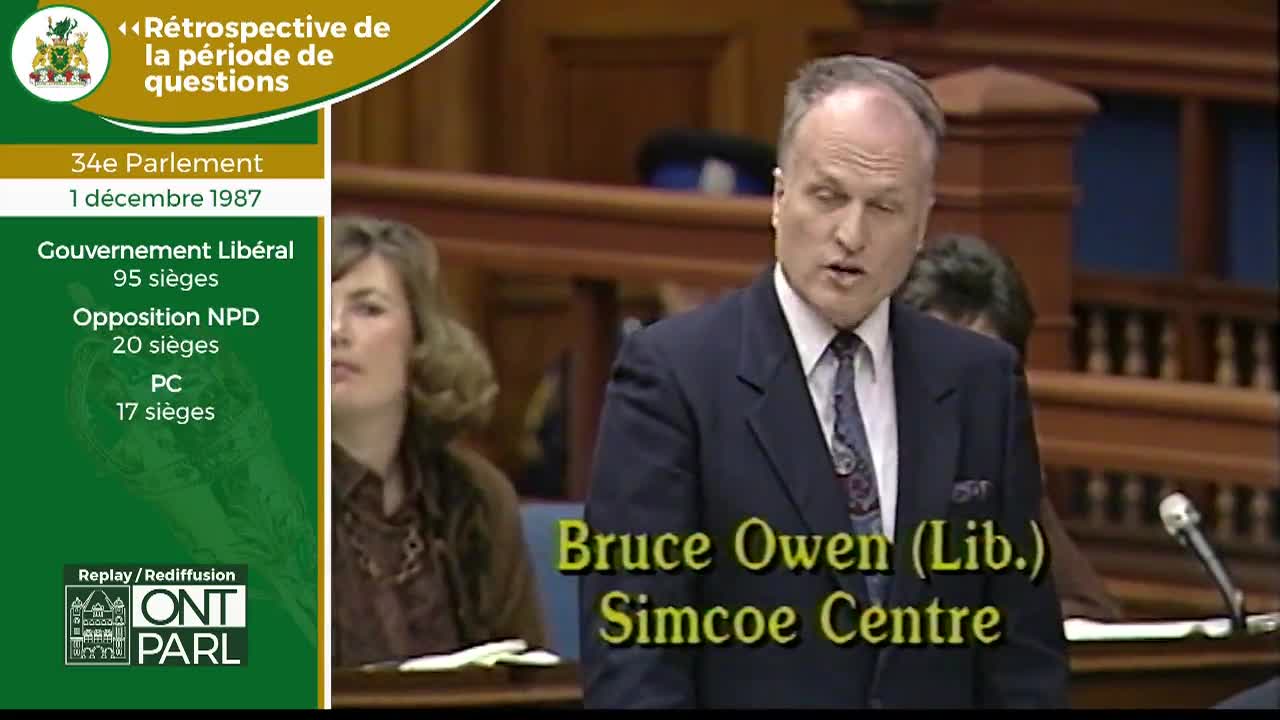 Bruce Owen, a Liberal MPP for Simcoe Centre, speaks during Question Period in the Legislative Assembly of Ontario. A woman sits behind him, her face turned slightly away.