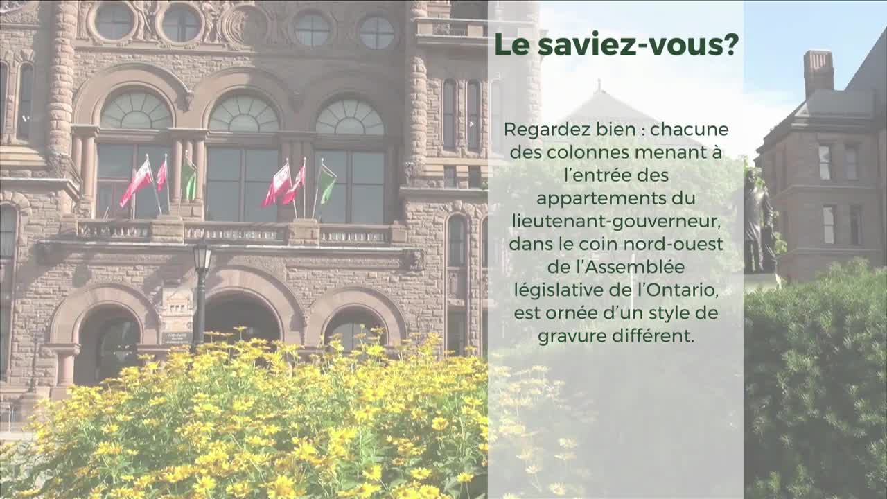 A person in a green suit stands on a balcony of the Legislative Assembly of Ontario. Red and white flags flutter beside them.