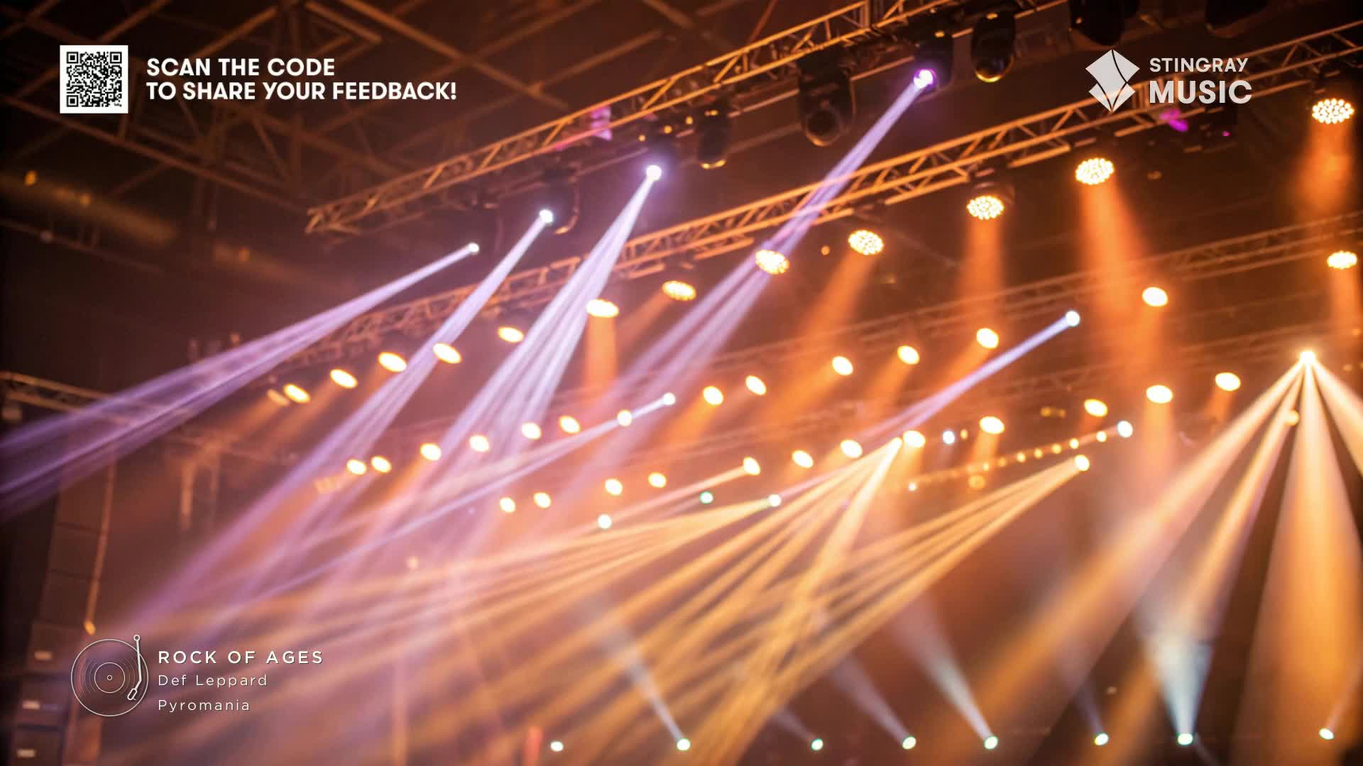 Bright beams of purple and orange light cut through the air, illuminating the stage as Stingray Music presents a classic rock show. The lights are focused, creating a dramatic atmosphere for the Def Leppard performance.

