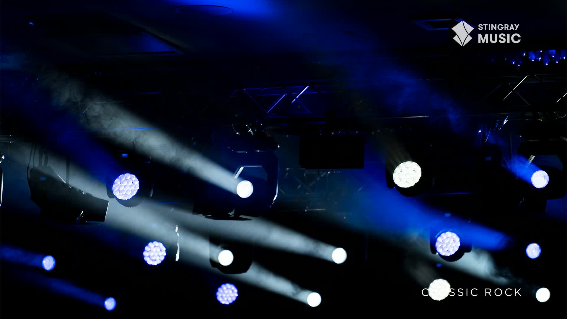 Bright spotlights cut through the darkness, casting beams of blue and white. It's a Stingray Classic Rock concert, and the stage is set for a big night.
