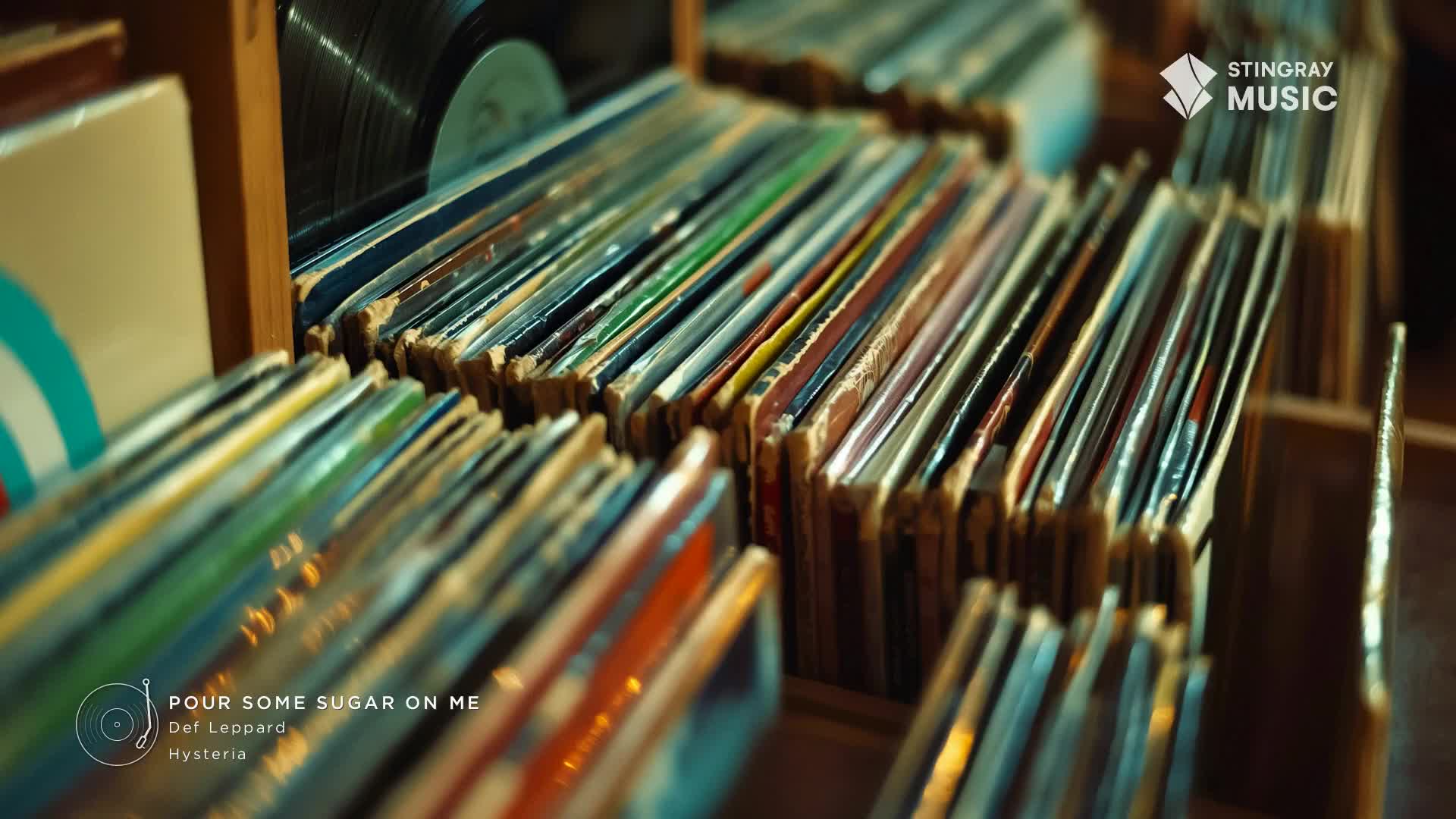 A collection of vinyl records, likely from Canada's Stingray Classic Rock, fills a wooden shelf. The album covers, worn and colorful, stand at attention, ready to play.
