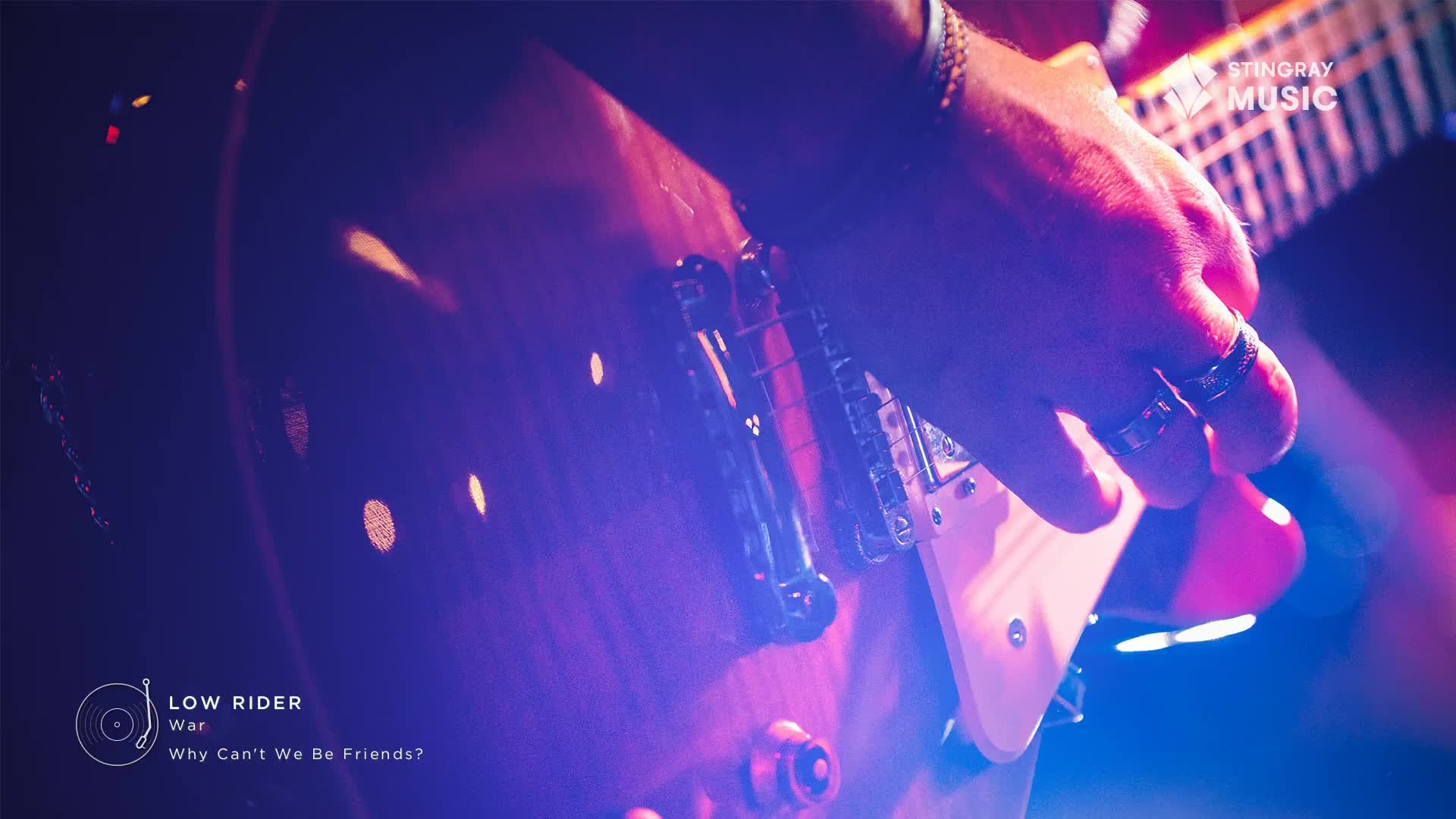 A hand, adorned with rings, strums the strings of a guitar, illuminated by a wash of purple and pink light. The music, playing on Stingray Classic Rock in Canada, is a familiar tune.
A hand, adorned with rings, strums the strings of a guitar, illuminated by a wash of purple and pink light. The music, playing on Stingray Classic Rock in Canada, is a familiar tune.