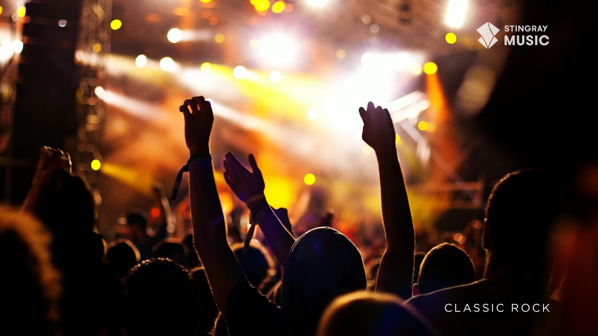 Arms are raised, silhouetted against the bright stage lights, clapping and cheering. Above the crowd, the Stingray Music logo is visible, promising a night of Classic Rock.
Arms are raised, silhouetted against the bright stage lights, clapping and cheering. Above the crowd, the Stingray Music logo is visible, promising a night of Classic Rock.