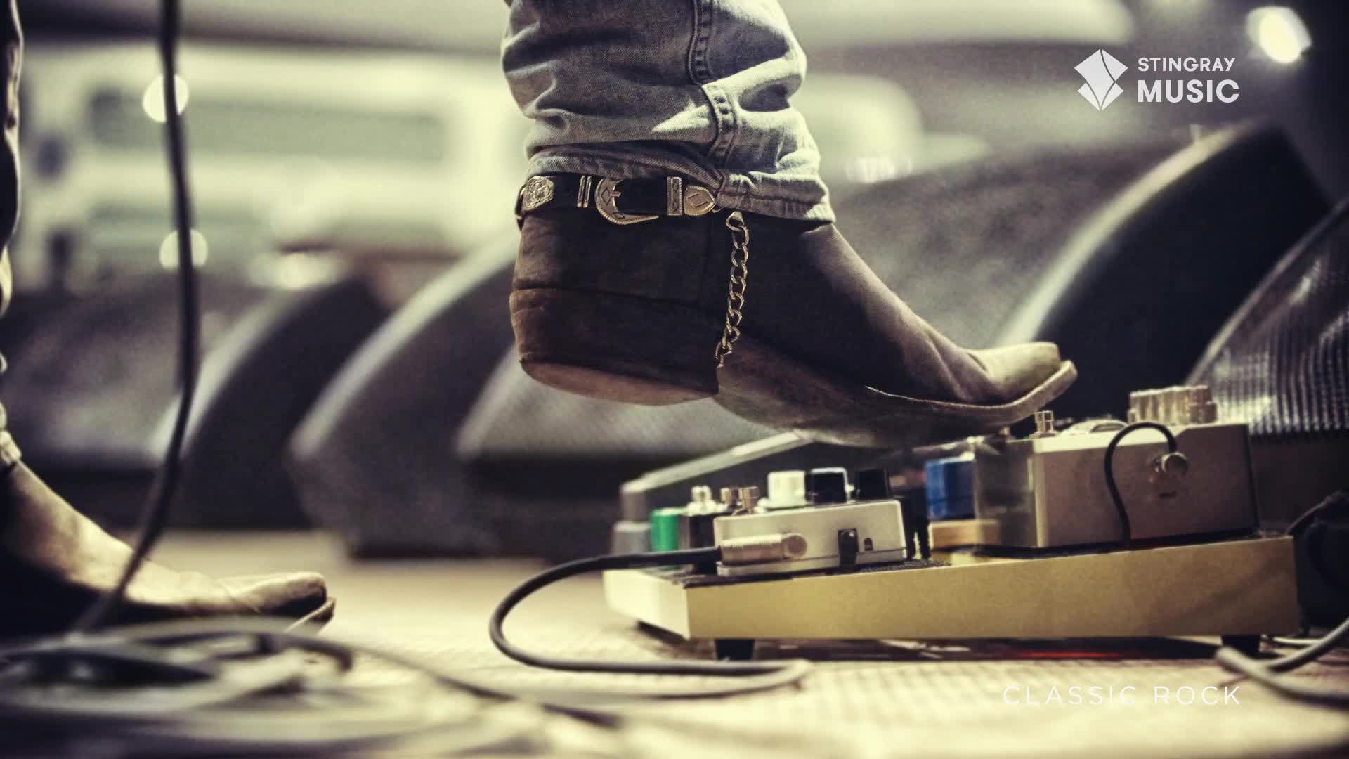 A boot, adorned with a chain, presses down on a pedal board, likely shaping the sound of the classic rock heard on Stingray Music. The stage lights are low, but the music is high.
A boot, adorned with a chain, presses down on a pedal board, likely shaping the sound of the classic rock heard on Stingray Music. The stage lights are low, but the music is high.