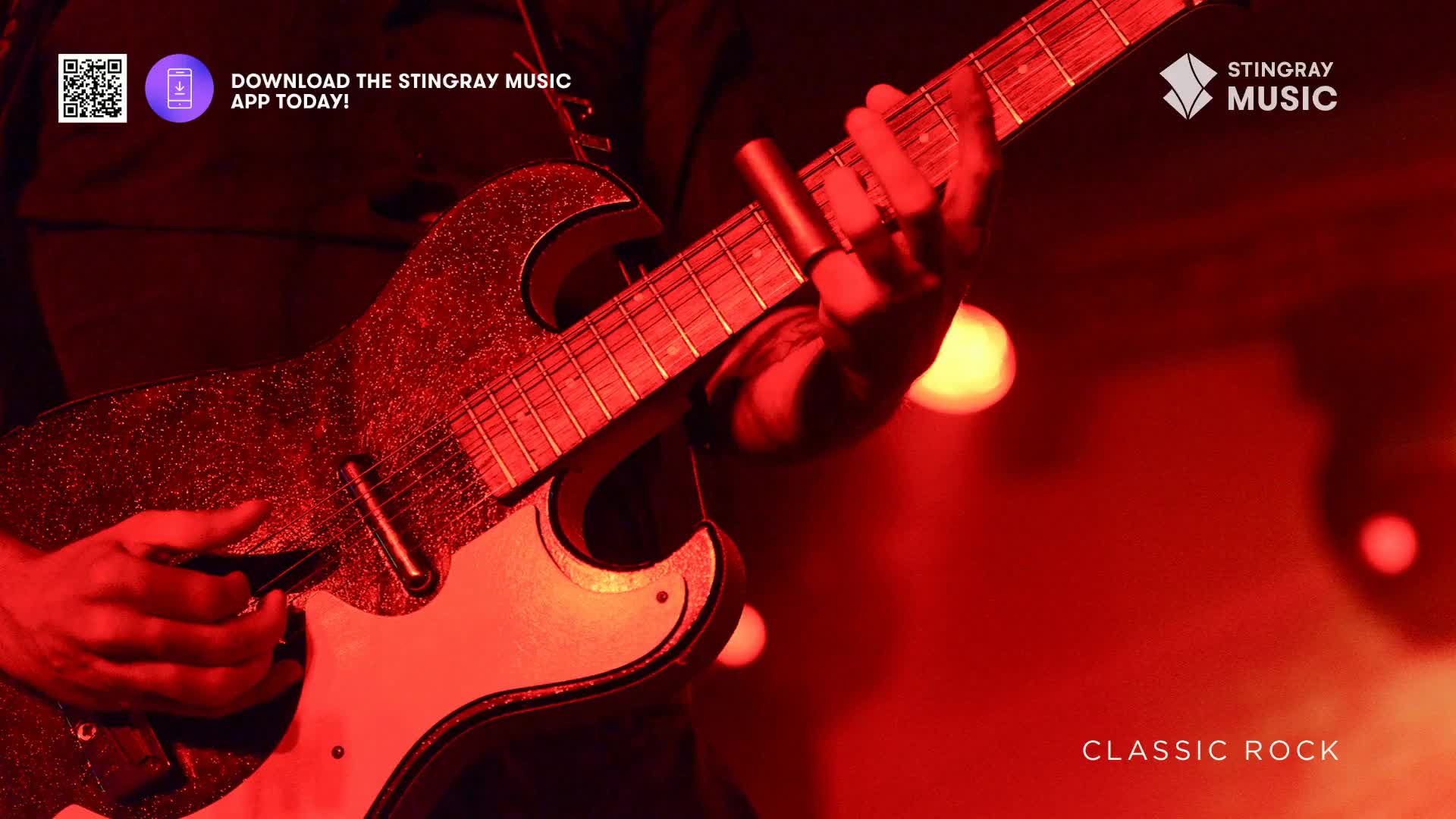 A hand, wearing a slide, glides across the frets of a glittery guitar. The stage is bathed in red light, perfect for a night of Stingray Classic Rock.
A hand, wearing a slide, glides across the frets of a glittery guitar. The stage is bathed in red light, perfect for a night of Stingray Classic Rock.