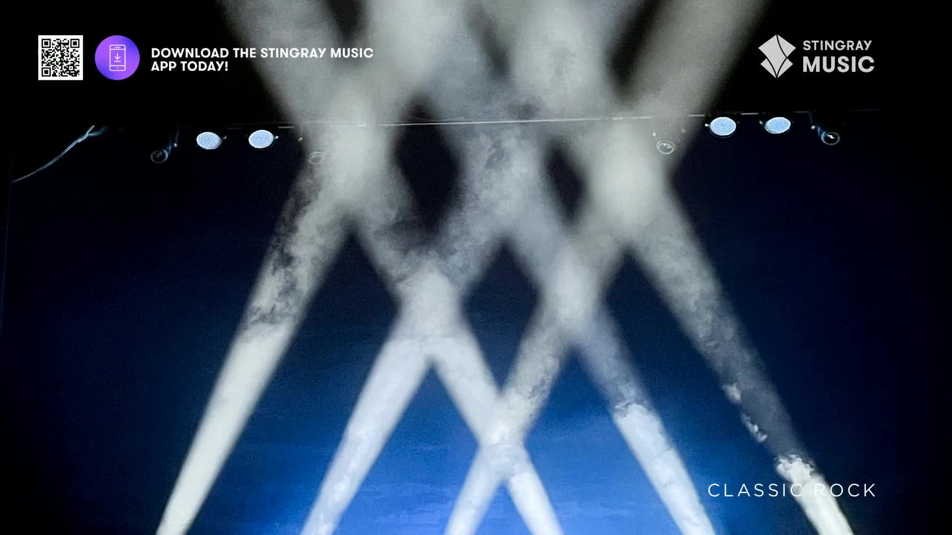 Bright beams of light crisscross the dark stage, creating a geometric pattern. The Stingray Music logo and the words "Classic Rock" hint at the music to come, a familiar sound from Canada.
