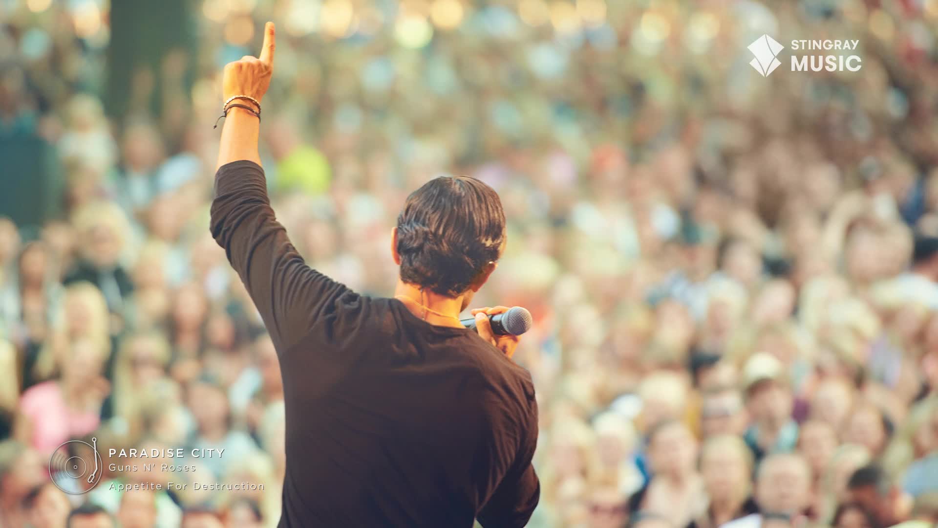 The singer, with his arm raised and finger pointing skyward, belts out "Paradise City" to a massive crowd. The air buzzes with anticipation, a classic rock anthem filling the Canadian night.
