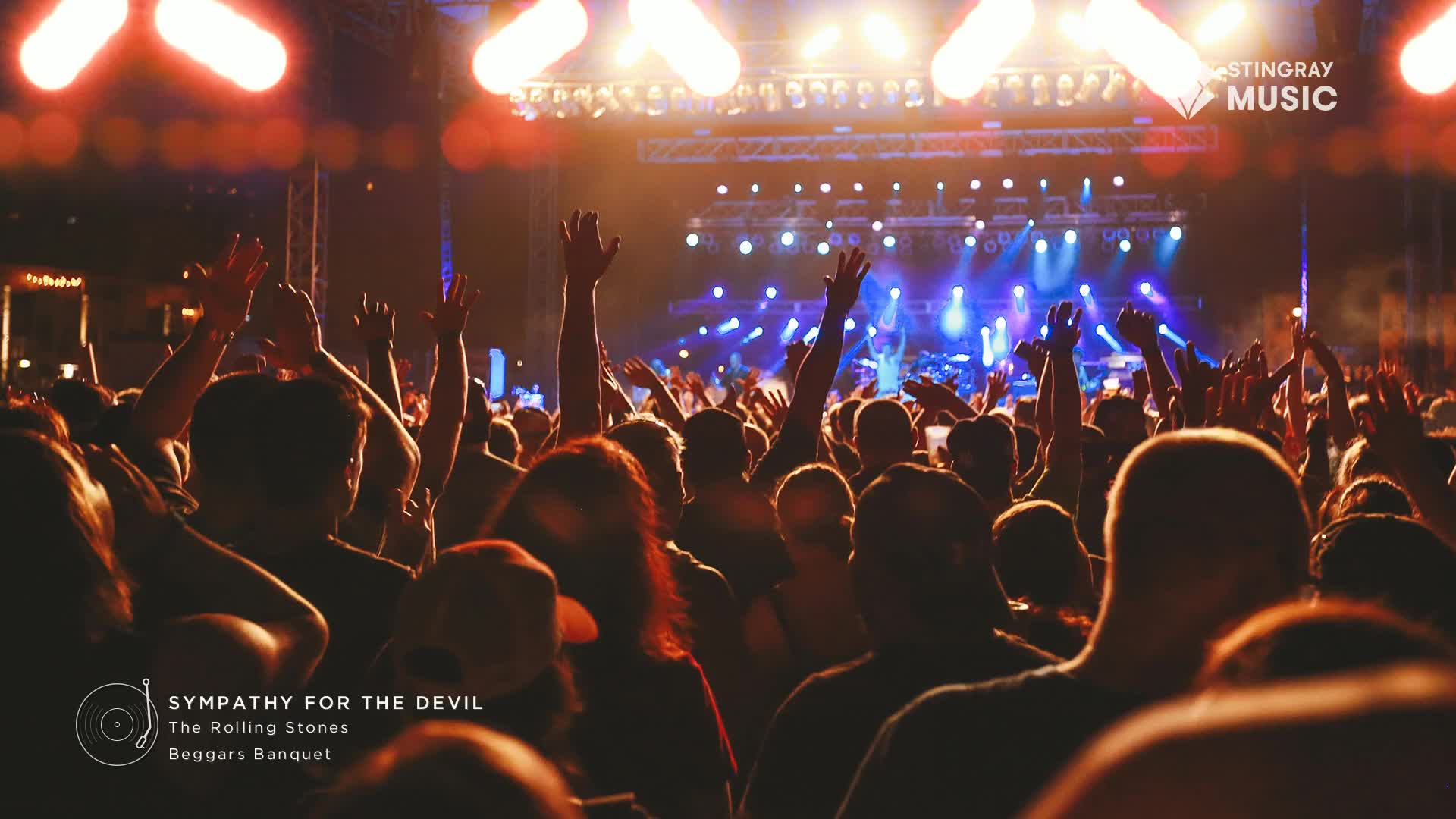 The stage lights are a dazzling spectacle, illuminating the crowd as they raise their hands. A Stingray Music logo is visible, hinting at a Canadian classic rock concert.
