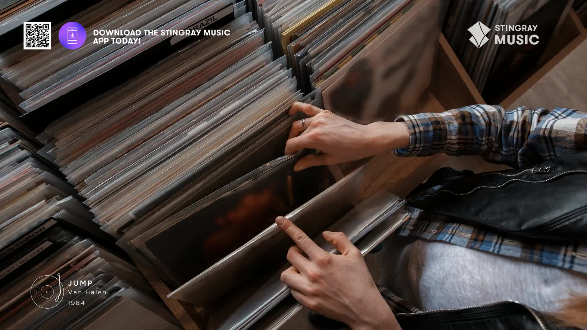 Fingers sift through rows of vinyl, searching for that perfect classic rock track. A hand pulls out a record, its cover art hinting at the music within.