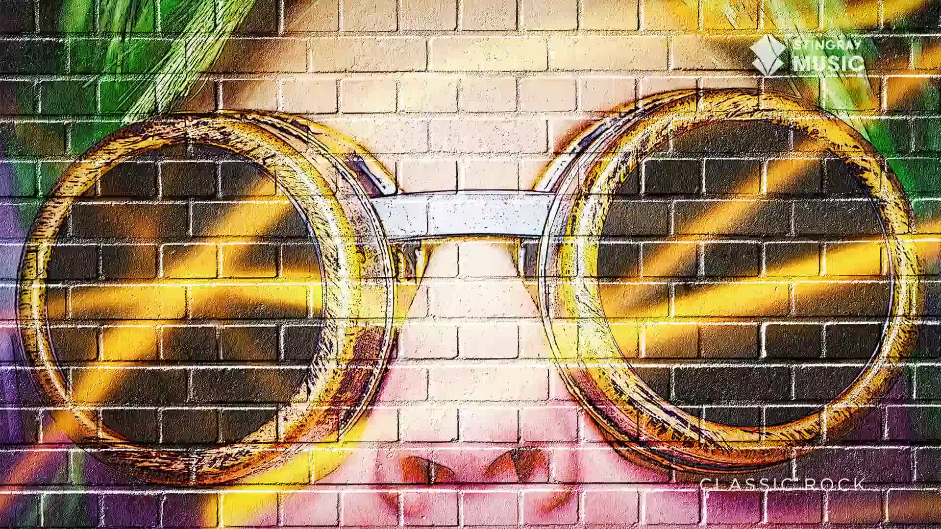 A pair of large, round, gold-rimmed goggles is painted onto a brick wall, casting a warm glow. The Stingray Classic Rock logo is visible in the upper right corner.