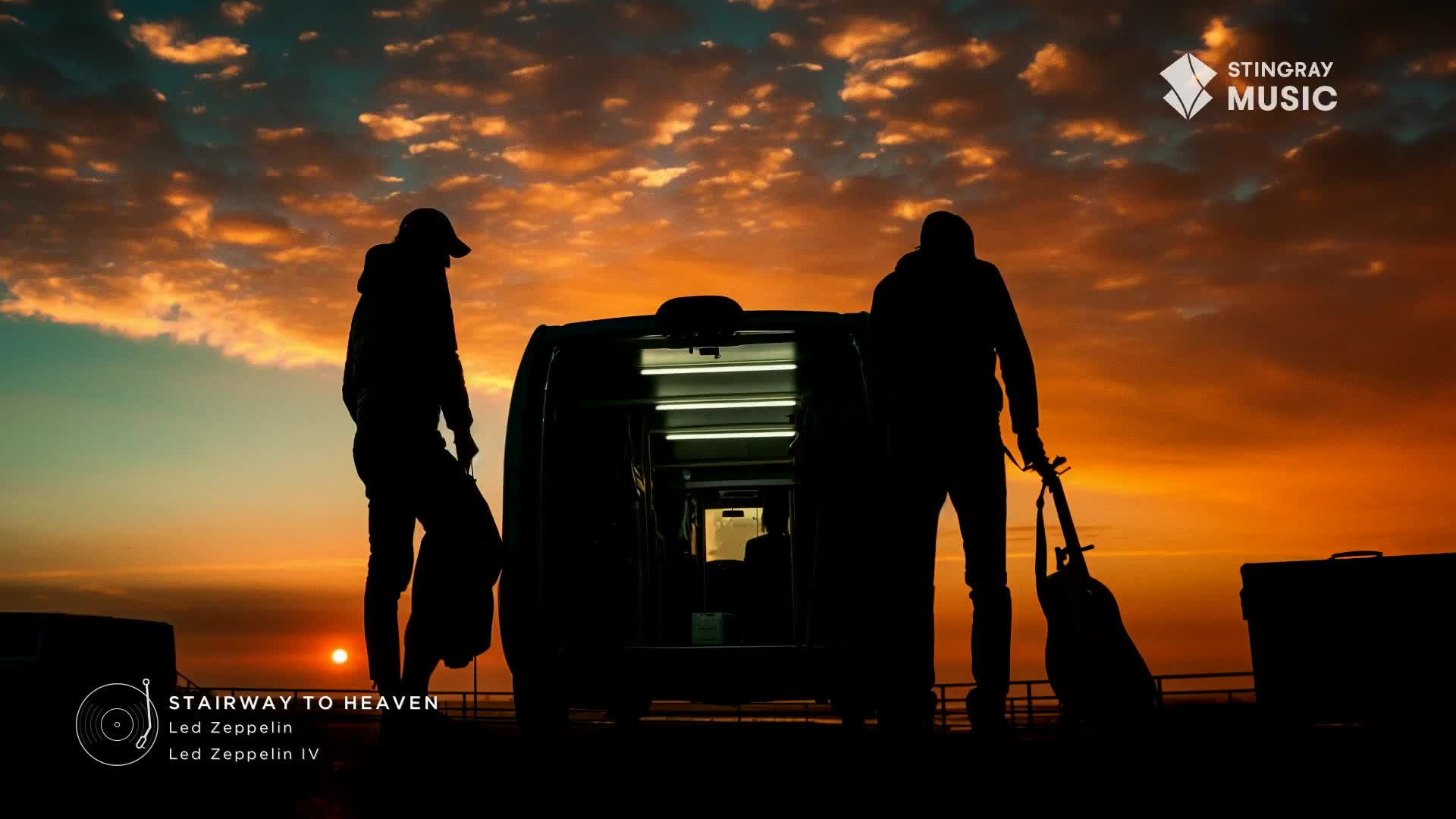 Two figures stand silhouetted against a vibrant Canadian sunset, one holding a guitar. A van sits between them, its interior lights glowing, as if ready for a Stingray Classic Rock tour.