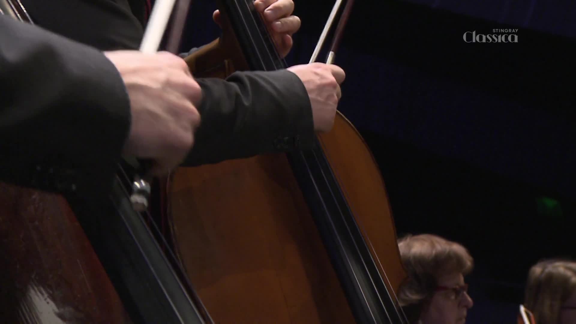 The musician's hands are poised over the cello, the bow ready to draw across the strings.  The Stingray Classica logo sits in the corner, hinting at a performance in Canada.
