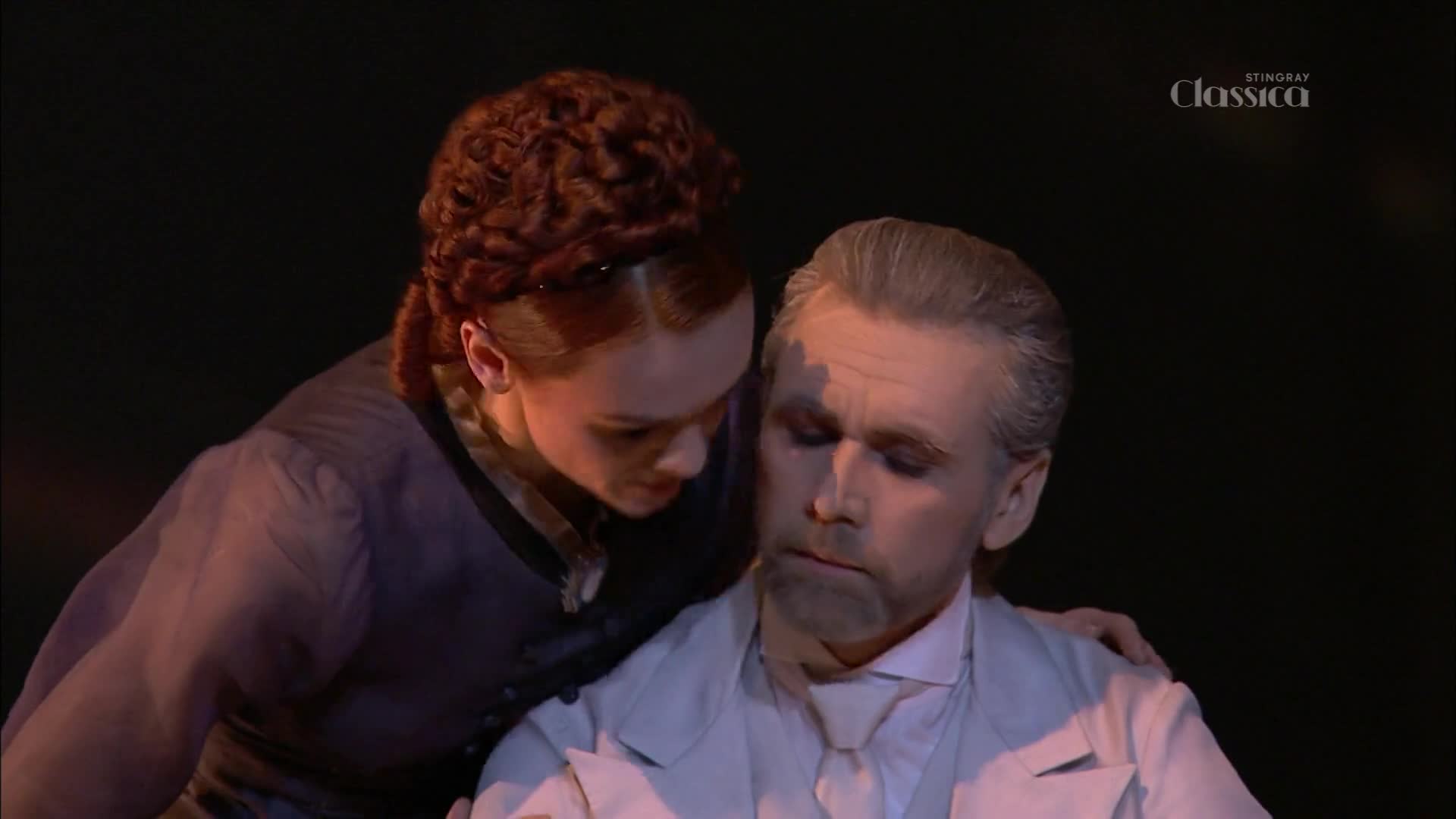 A young woman leans in, her hand resting on an older man's shoulder as he looks down. The Stingray Classica logo is visible in the upper right corner.