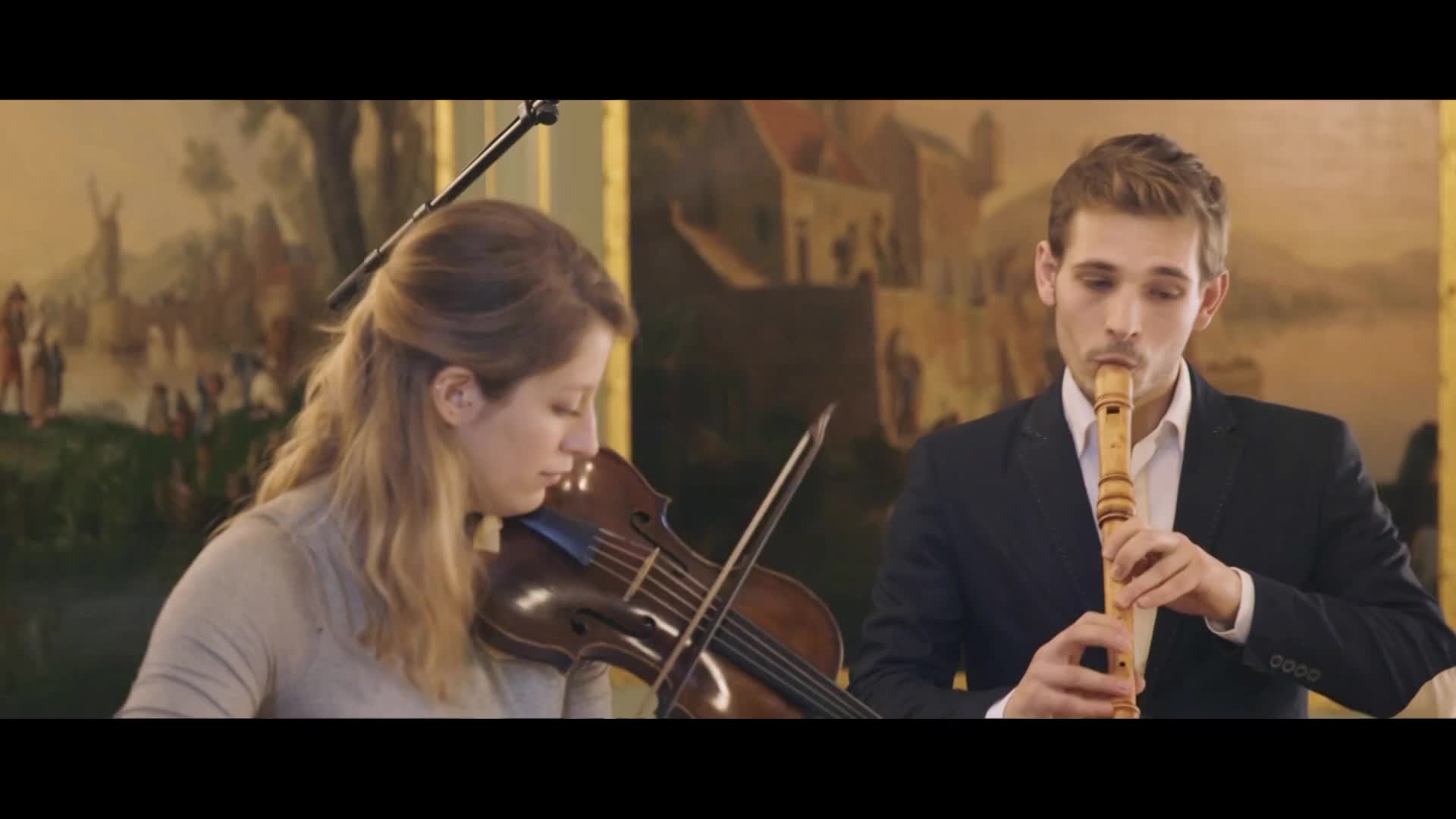 A woman plays the violin with focused intensity, her bow gliding across the strings. Beside her, a man plays a wooden recorder, his fingers dancing over the holes.