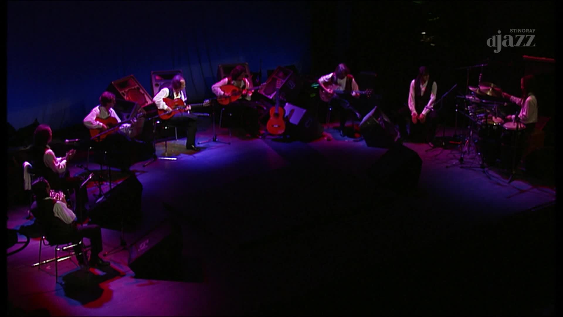 Under the blue stage lights, guitarists pluck at their instruments, while a drummer keeps the rhythm. The Stingray DJAZZ logo is visible, and the music is flowing from Canada.

