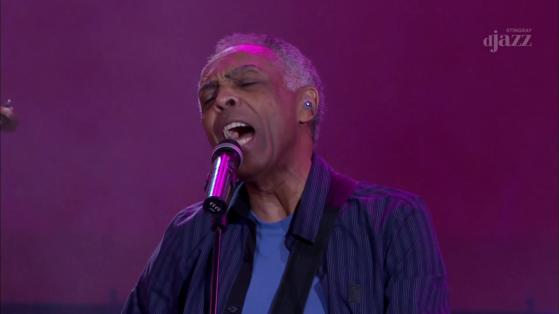 The singer is belting into the microphone, his eyes closed as he pours himself into the song. The Stingray DJAZZ logo glows in the background as he performs in Canada.
