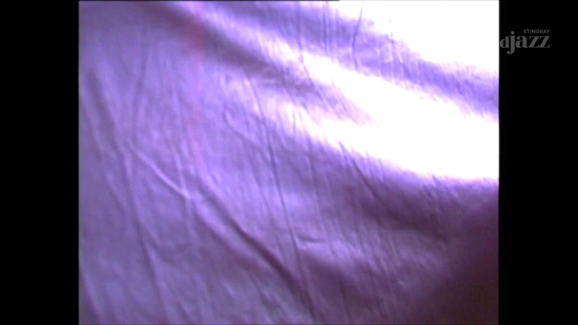 A rippling, purple fabric fills the screen, with light washing over it from the top. The Stingray DJAZZ logo is visible in the top right corner.
