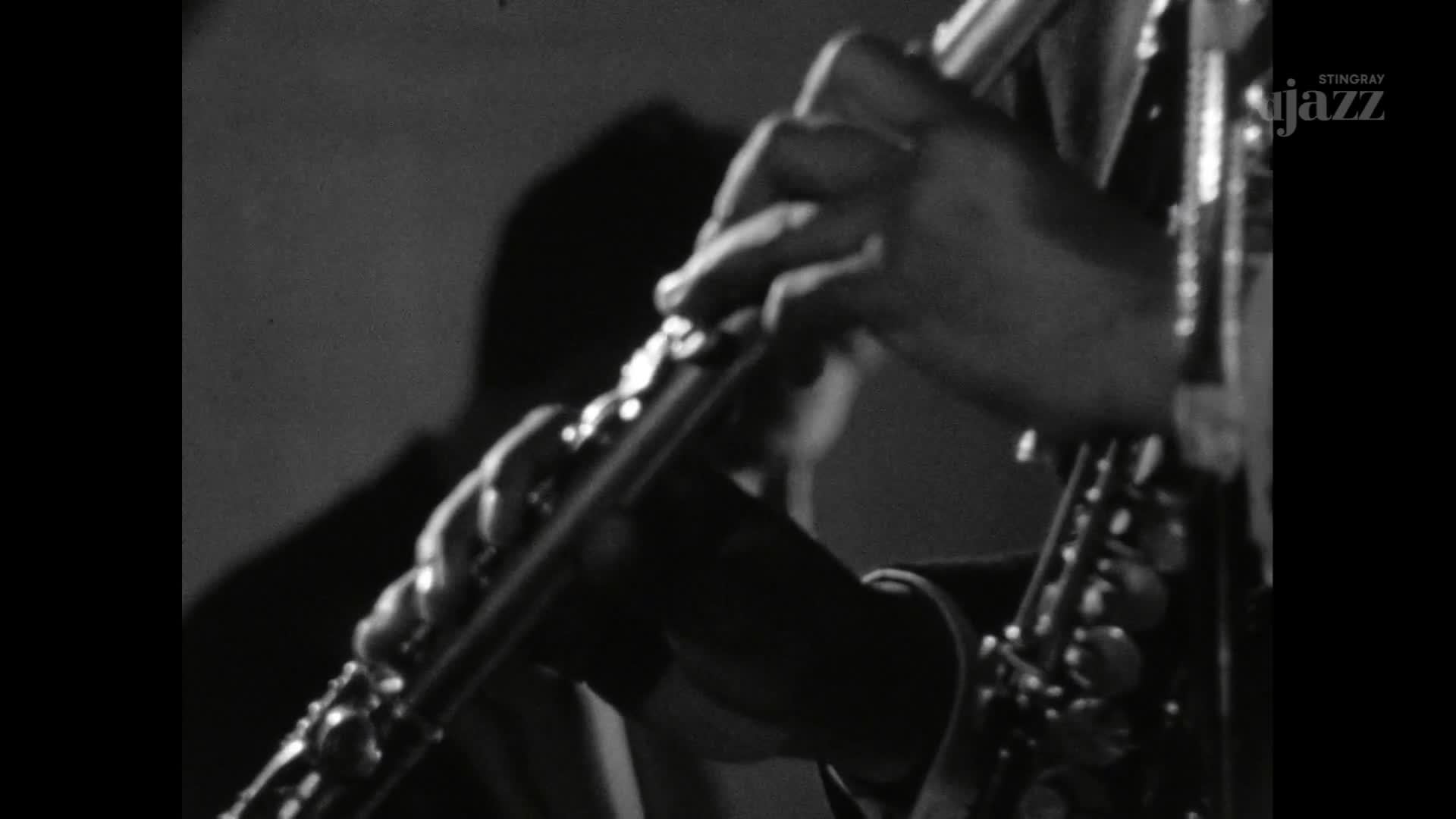 Fingers dance over the keys of a flute, the musician's hands in sharp focus. The Stingray DJAZZ logo appears in the corner, a reminder of the Canadian broadcast.

