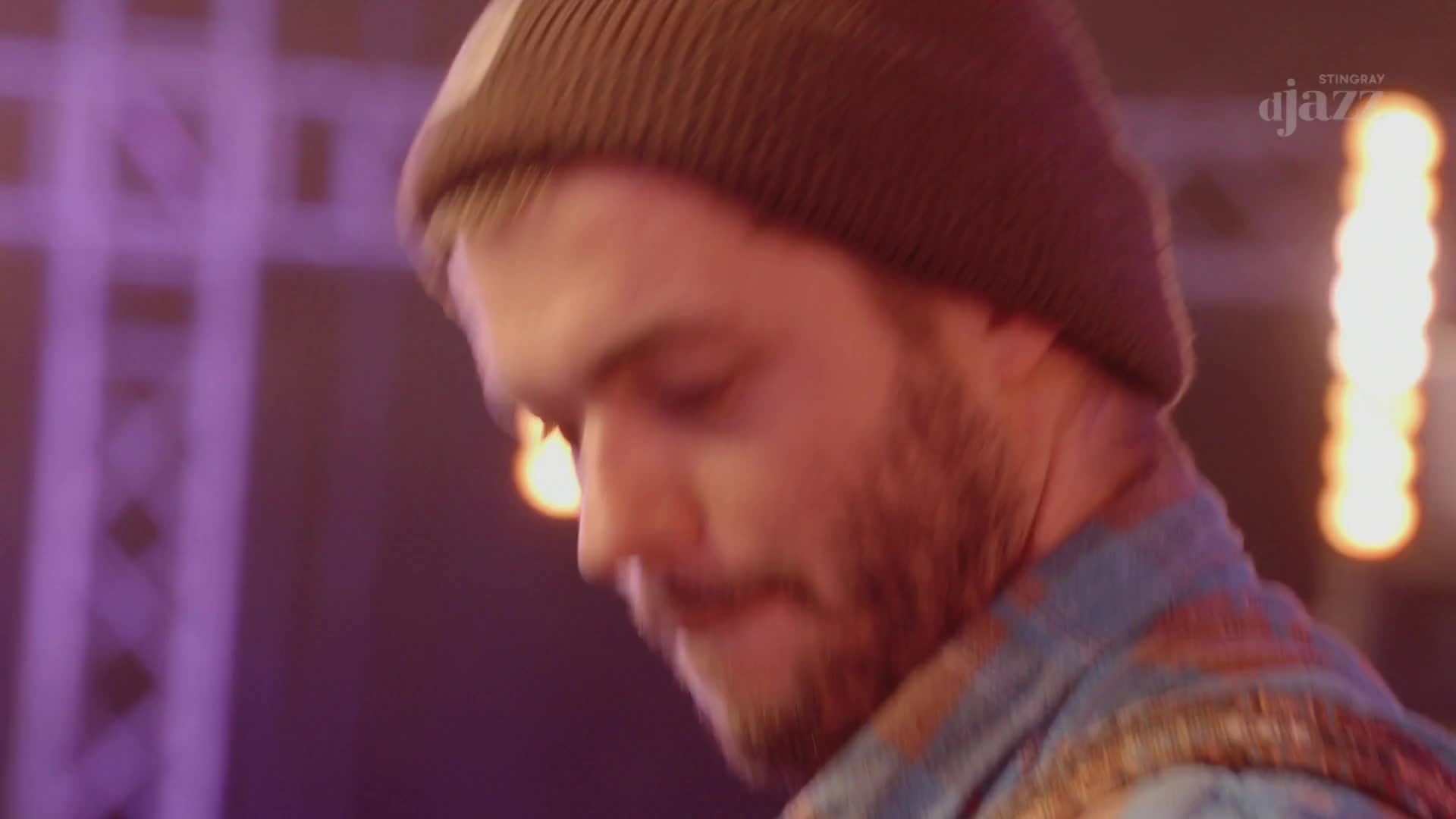 A man in a beanie, likely from Canada, is focused on something just out of view. The Stingray DJAZZ logo glows in the background, illuminating the stage.
A man in a beanie, likely from Canada, is focused on something just out of view. The Stingray DJAZZ logo glows in the background, illuminating the stage.