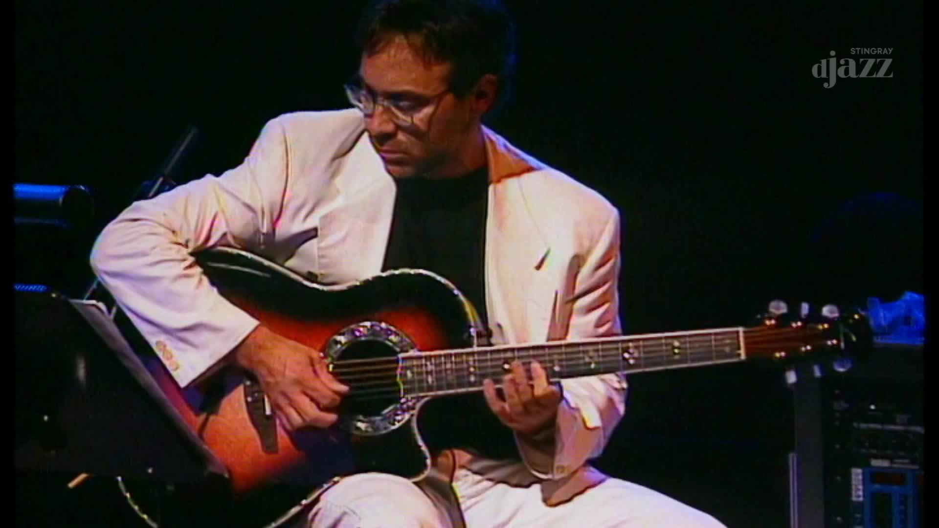 A musician, wearing a white jacket, is focused on the fretboard of his acoustic guitar. His fingers move across the strings as he plays, part of a broadcast on Canada's Stingray DJAZZ.
A musician, wearing a white jacket, is focused on the fretboard of his acoustic guitar. His fingers move across the strings as he plays, part of a broadcast on Canada's Stingray DJAZZ.