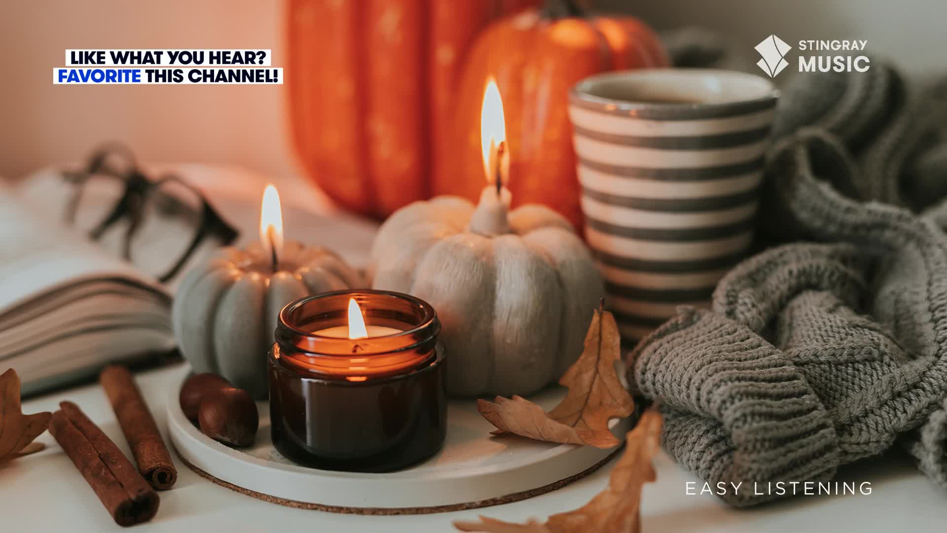 The flames of the candles flicker, casting a warm glow on the small pumpkins and a cozy blanket. Cinnamon sticks and a mug of something warm suggest the comfort of a Canadian autumn, all set to the easy listening sounds of Stingray Music.

