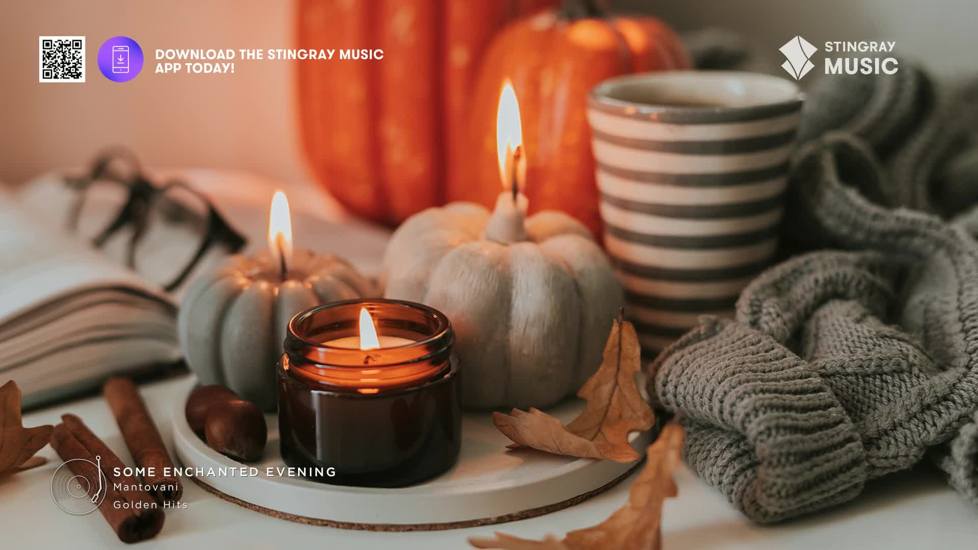 The flames of three candles flicker, casting a warm glow on the gourds and fallen leaves. A cozy scene, perfect for a relaxing evening, perhaps while listening to Stingray Easy Listening from Canada.
