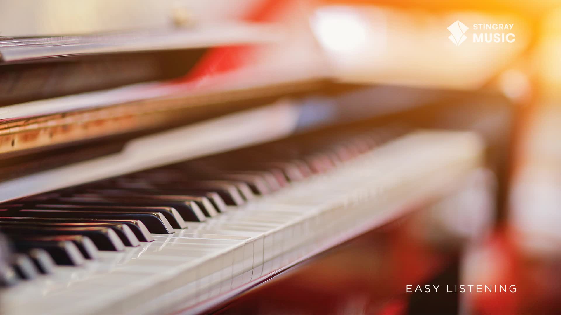 The black and white keys of a piano stretch away, reflecting the warm light. The Stingray Easy Listening logo is visible, hinting at the gentle music that might soon fill the air.
