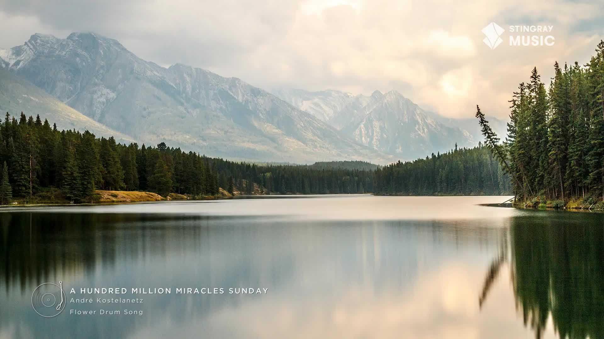 The still water reflects the mountains and trees, a scene of Canada's natural beauty.  This image, perfect for Stingray Easy Listening, evokes a sense of peace.
