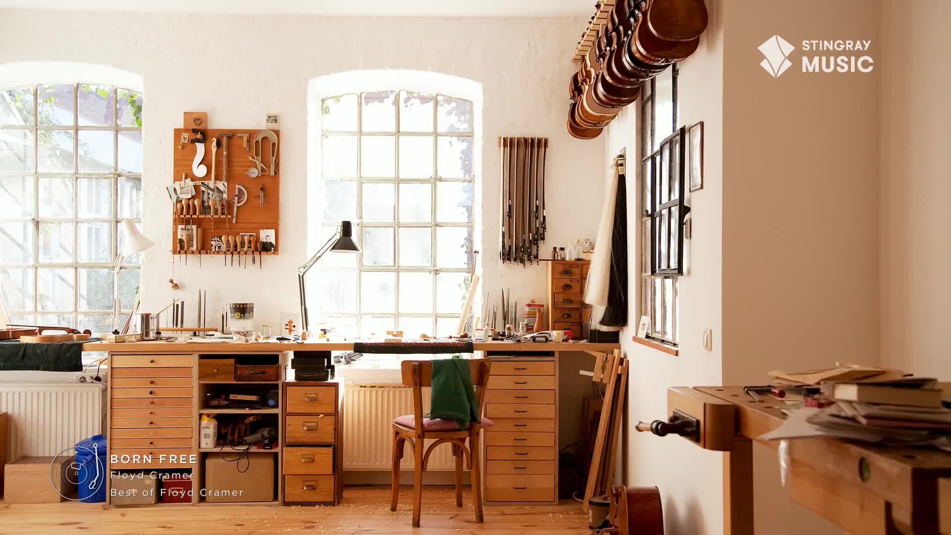 Sunlight streams through the large windows of a workshop, illuminating a workbench cluttered with tools and materials. Violins hang in a row, and the air feels quiet, like the best of Stingray Easy Listening from Canada.
Sunlight streams through the large windows of a workshop, illuminating a workbench cluttered with tools and materials. Violins hang in a row, and the air feels quiet, like the best of Stingray Easy Listening from Canada.