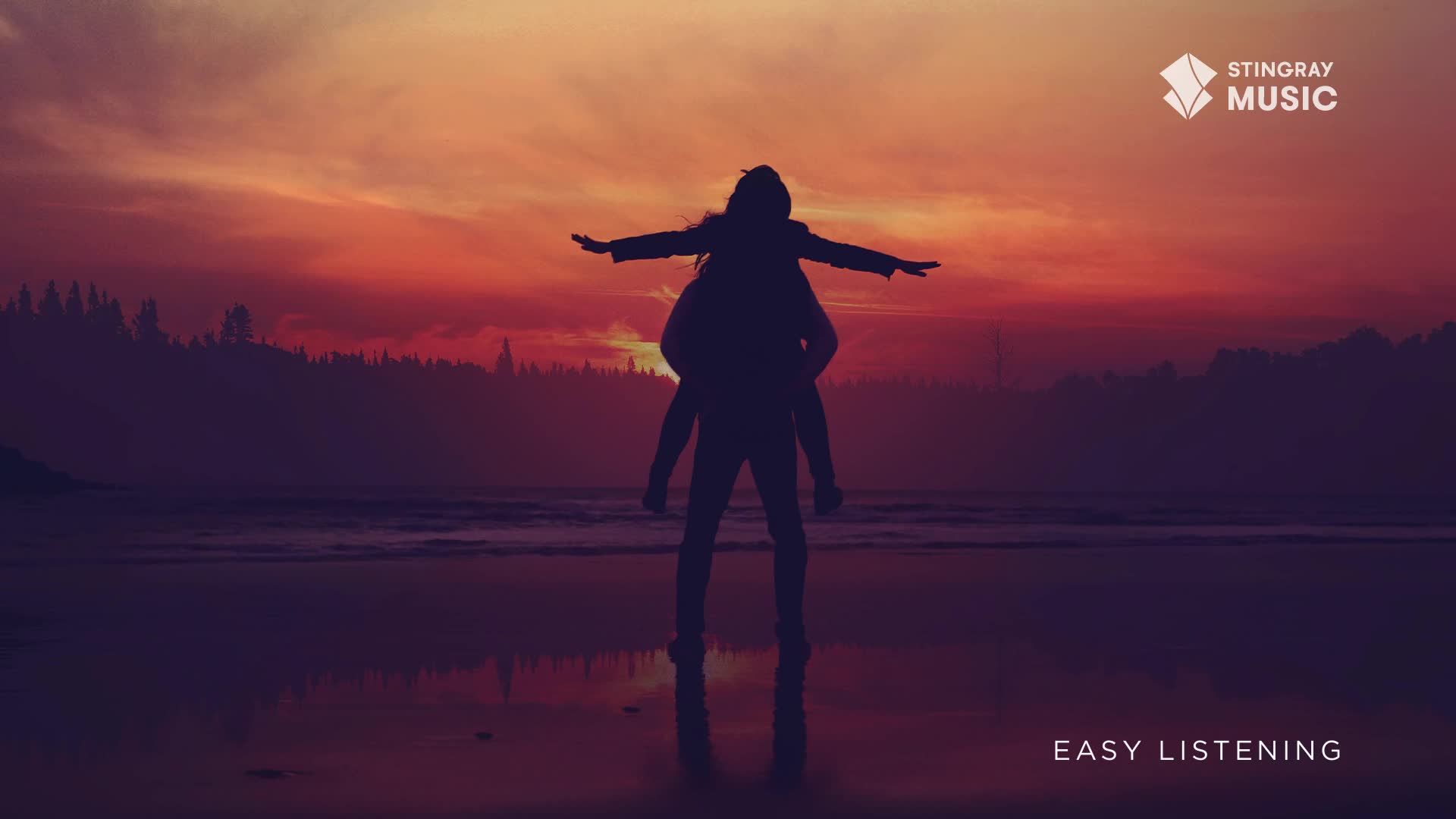 A person carries another on their back, arms outstretched like wings, silhouetted against a fiery sunset over the Canadian coast. The Stingray Easy Listening logo sits in the corner, a reminder of the tranquil scene.
A person carries another on their back, arms outstretched like wings, silhouetted against a fiery sunset over the Canadian coast. The Stingray Easy Listening logo sits in the corner, a reminder of the tranquil scene.