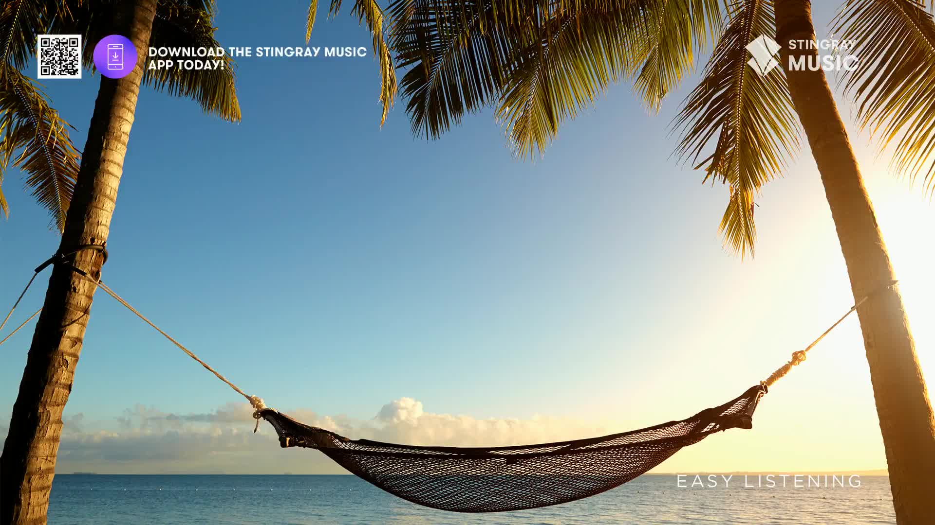 The sun dips low, casting a warm glow over the ocean as a hammock sways gently between two palm trees. This Canadian scene, perfect for Stingray Easy Listening, promises a moment of pure relaxation.
