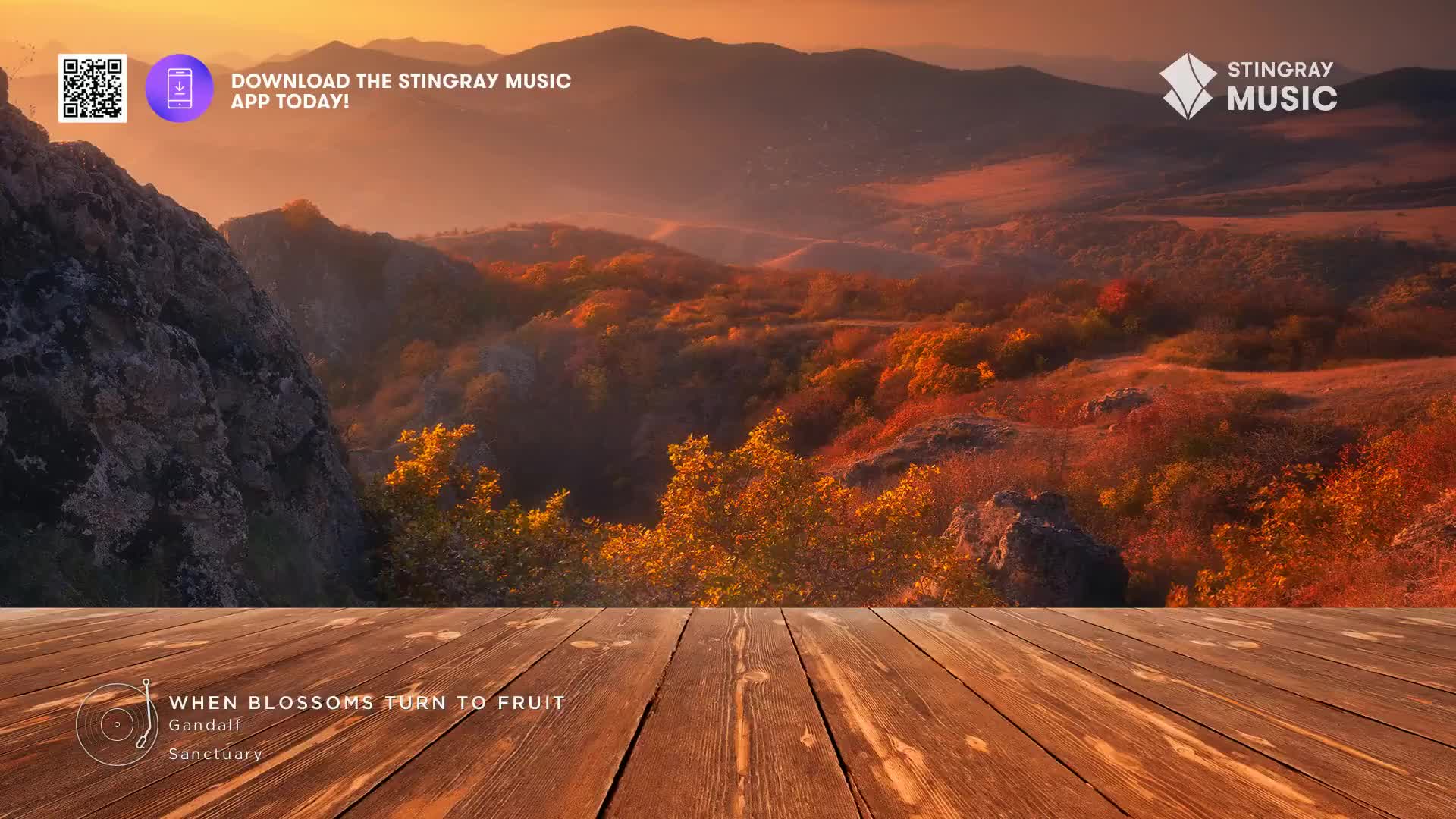 The sun dips below rolling hills, painting the autumn foliage in warm, golden light.  A rustic wooden deck stretches out before this Canadian vista, offering a perfect spot to enjoy the quiet beauty.