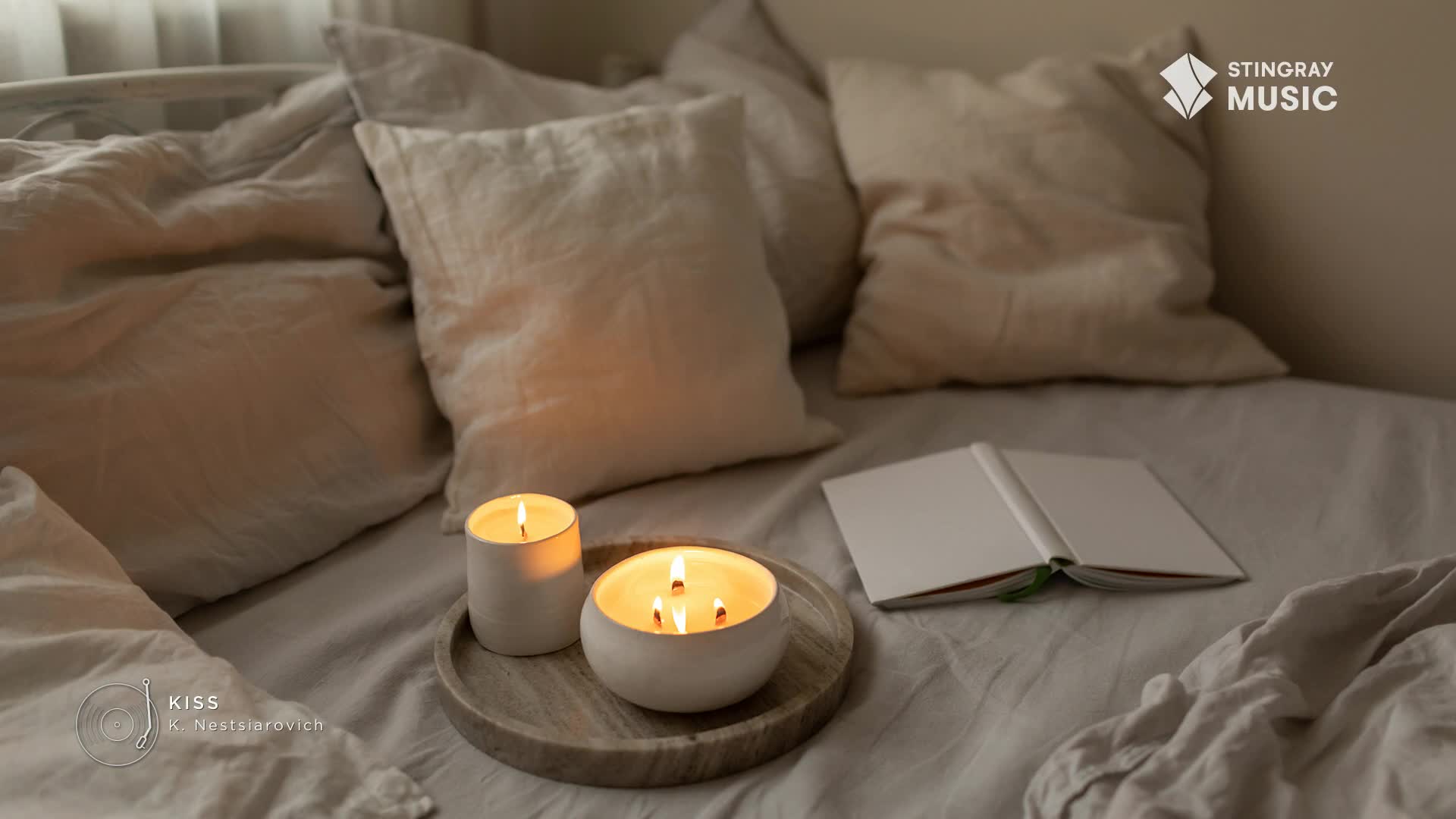 The gentle glow of lit candles illuminates a rumpled bed, while an open book rests nearby. Soft, neutral-toned linens create a cozy atmosphere, perfect for a quiet moment with Stingray Easy Listening. The gentle glow of lit candles illuminates a rumpled bed, while an open book rests nearby. Soft, neutral-toned linens create a cozy atmosphere, perfect for a quiet moment with Stingray Easy Listening.