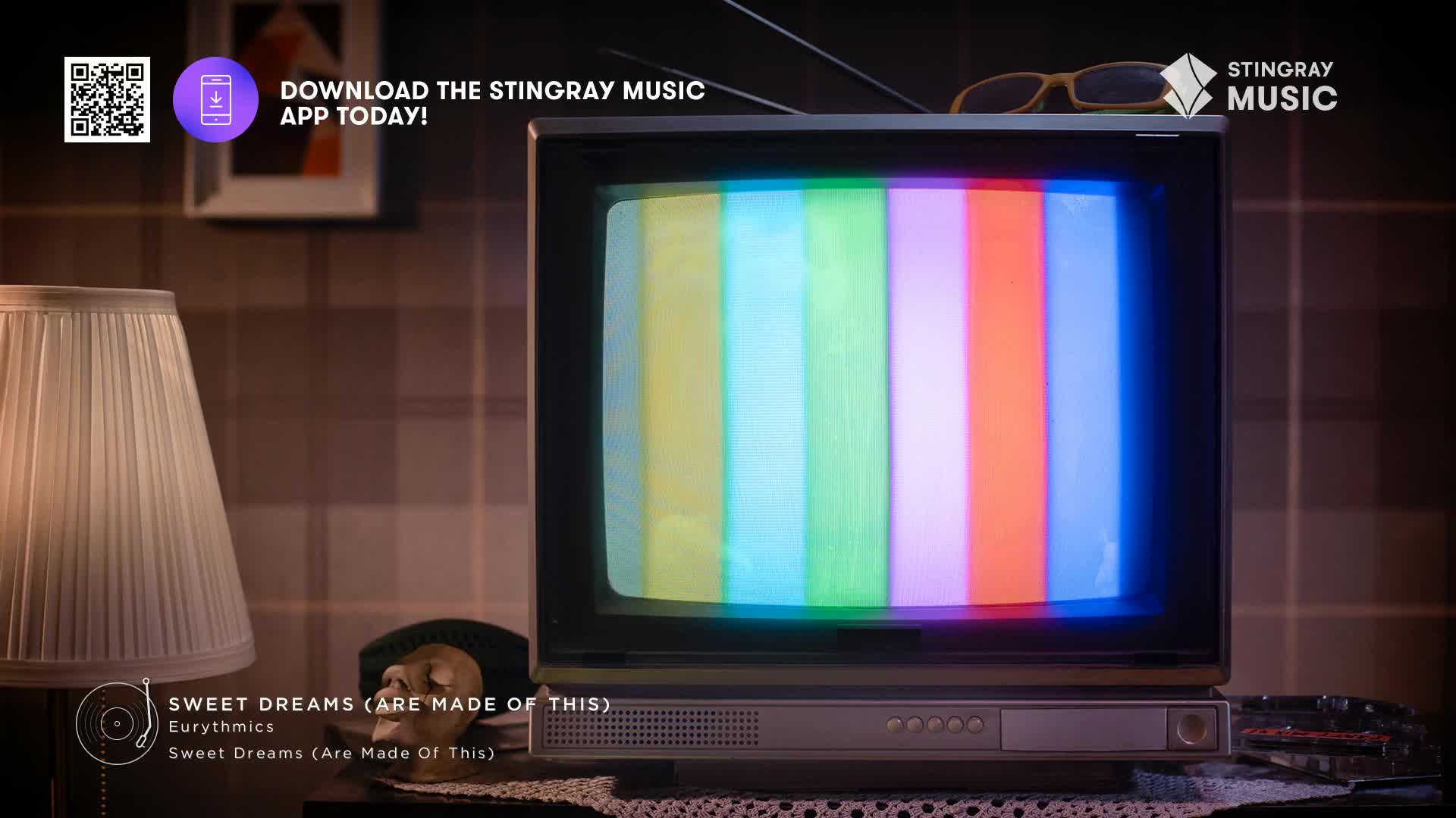 A vintage TV displays a colourful test pattern, the screen's glow illuminating the room. The Stingray Music logo, a Canadian company, sits in the corner, and a record player icon advertises Eurythmics' "Sweet Dreams (Are Made of This)."
