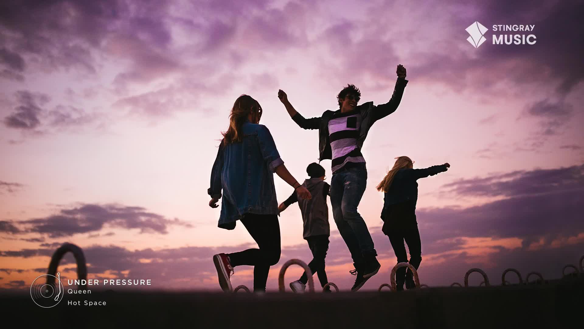 A group of people leap into the air against a purple and pink sky, arms outstretched. The silhouette of the group is set against the backdrop of a Canadian sunset, likely a Stingray Everything '80s playlist kind of moment.
