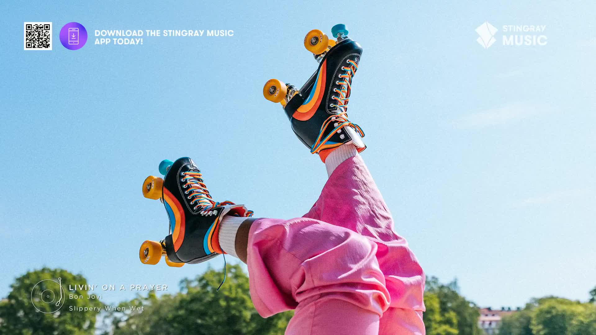 Roller skates with rainbow stripes and orange wheels are pointed towards the sky. The person wearing them is in bright pink pants, with the track of Bon Jovi's "Livin' on a Prayer" playing on Stingray Music.
