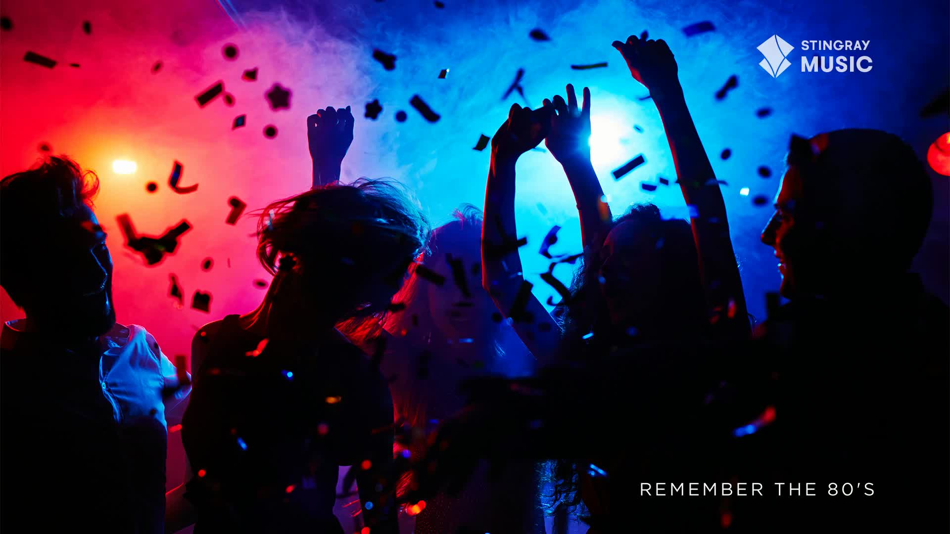 Confetti drifts down as people dance, their silhouettes illuminated by red and blue lights. Arms are raised, and heads are thrown back, lost in the music from Stingray Everything '80s.
