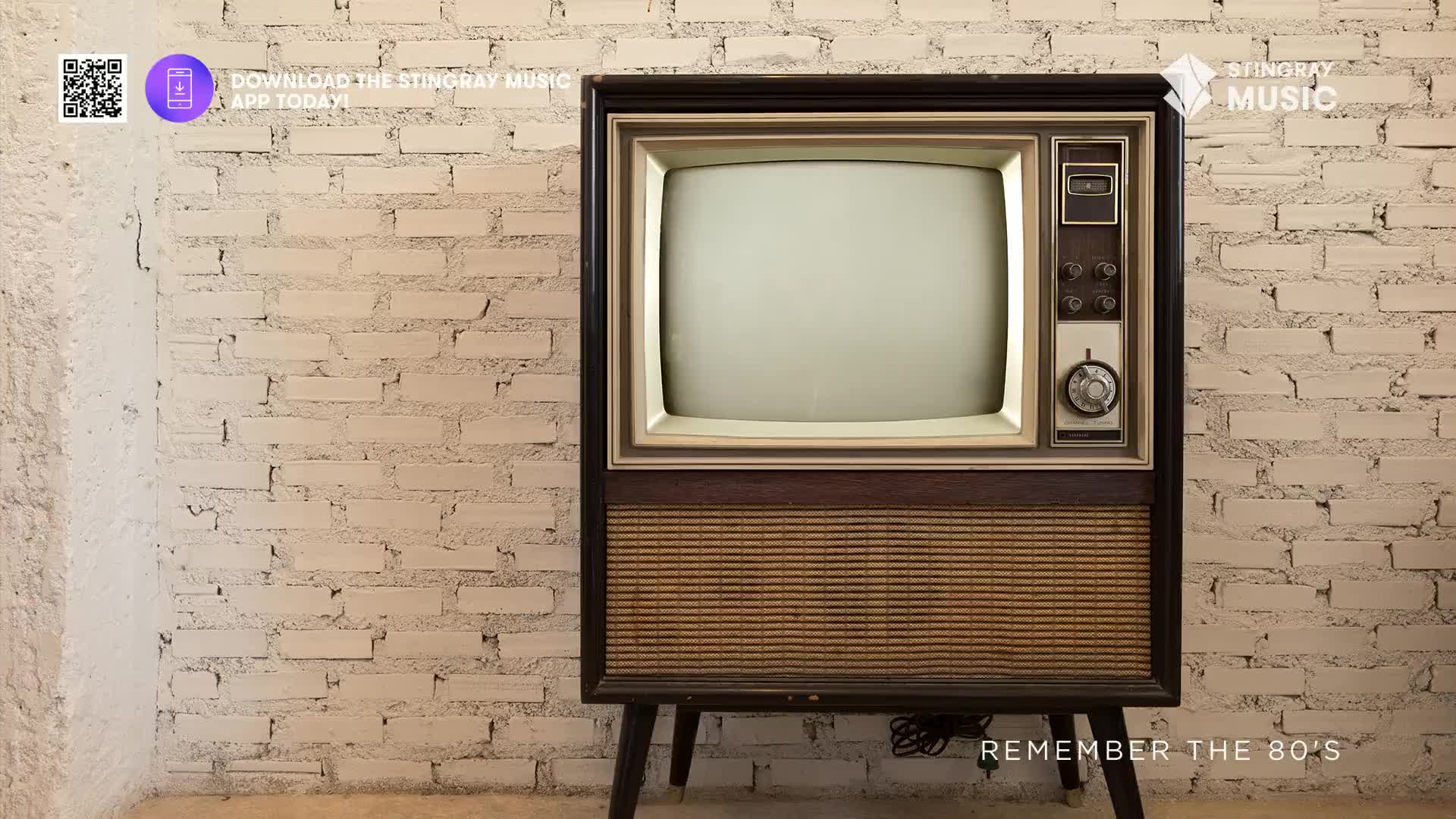 The retro television is on, its screen a blank canvas against the white brick. A faint hum emanates from the vintage set, promising a blast from the past.