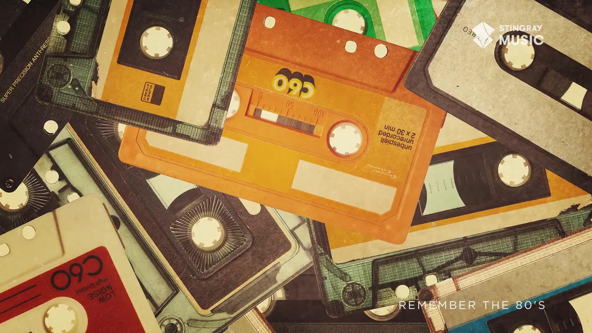 A pile of vintage cassette tapes, some orange, some green, and some dark grey, are scattered across a surface. The label "REMEMBER THE 80'S" appears in the lower right corner, hinting at the era of these analog music carriers.