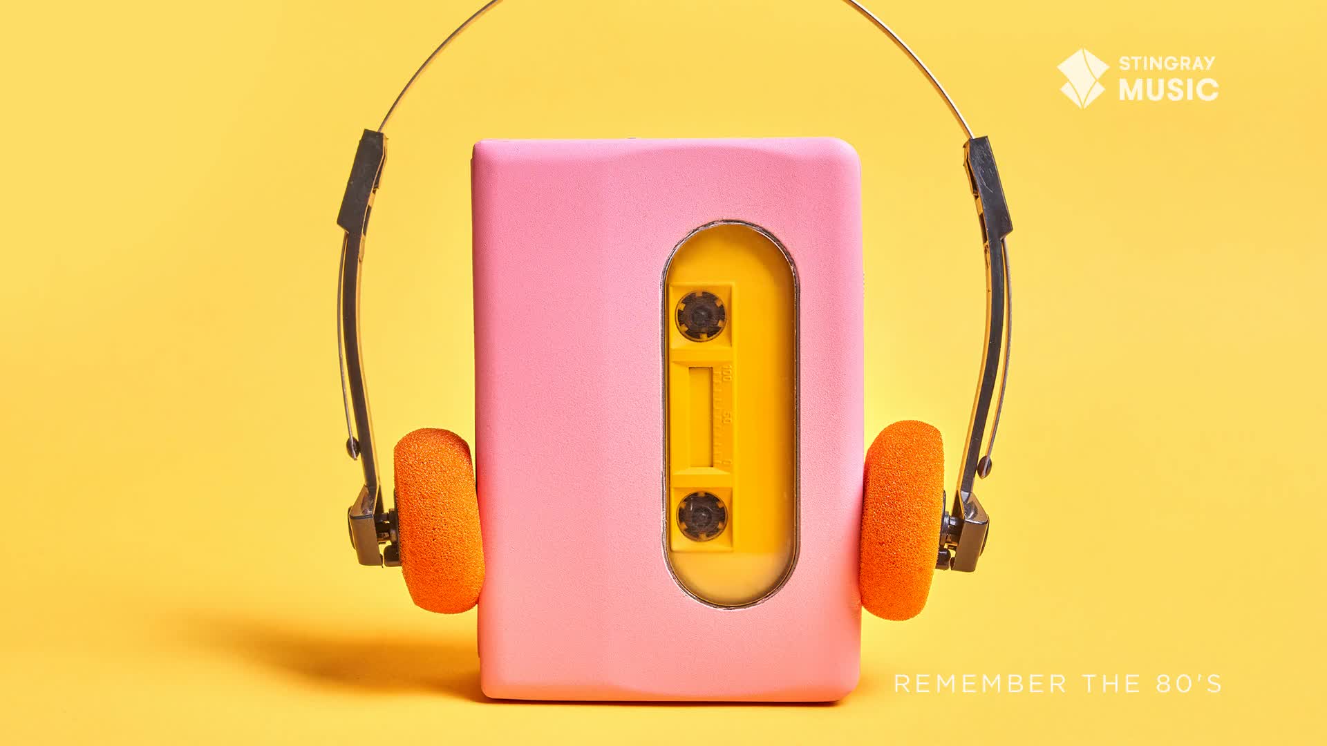 A pink cassette player with orange headphones sits ready. A yellow cassette tape is visible inside, ready to play some '80s hits.