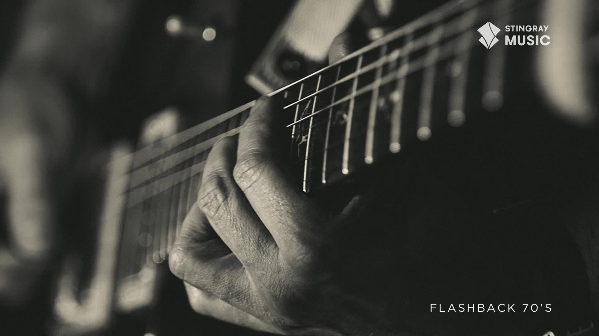 Fingers press down on the guitar strings, the hand forming a chord. The Stingray Flashback 70's logo sits in the corner of the frame, hinting at the music to come.
