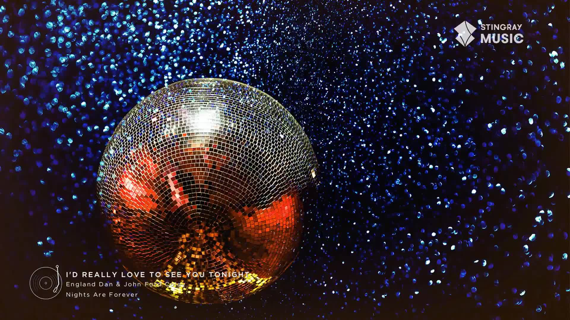 A disco ball, reflecting warm tones, hangs in front of a starry, dark blue backdrop. The Stingray Music logo and a song title from the 70s, "I'd Really Love to See You Tonight," are displayed at the bottom.

